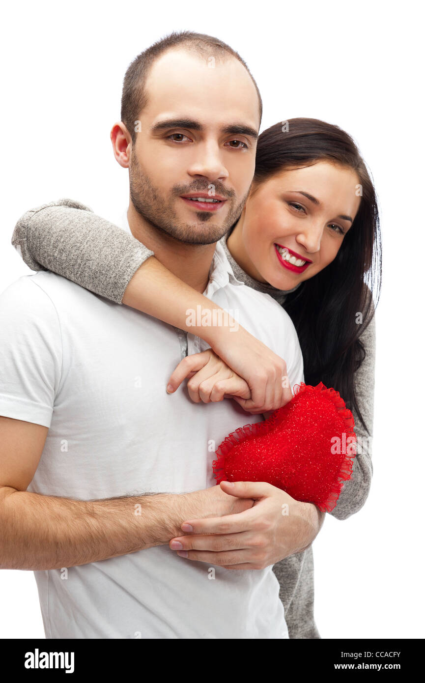 Junge Erwachsene Brautpaar mit roten Herz auf weißem Hintergrund, umarmen und lachen Stockfoto