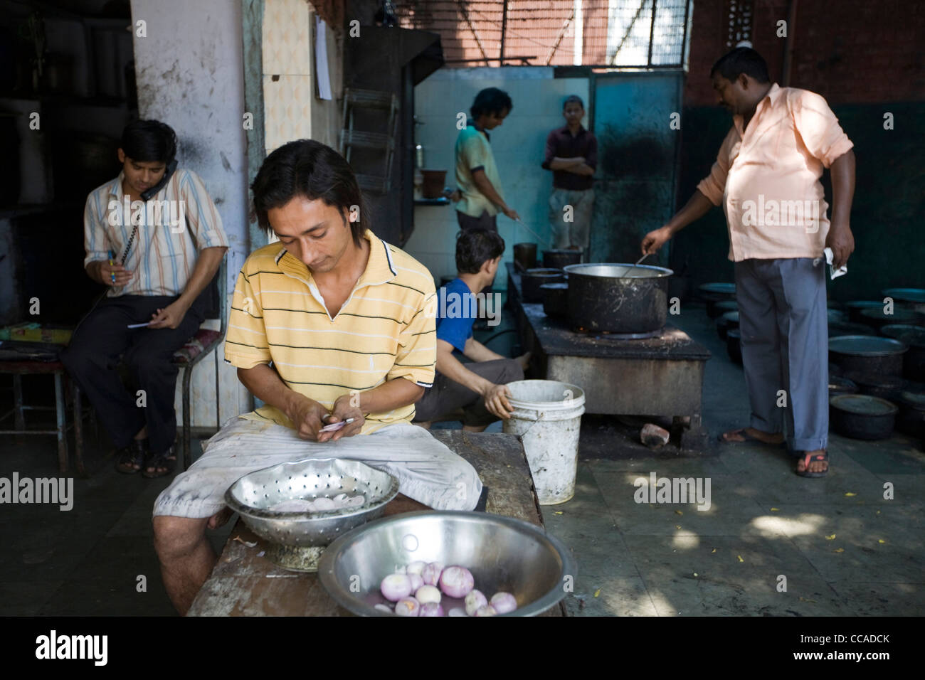 Nasir eine Jungkoch Koteletts Zwiebeln vor der Küche im Babu Shahi Bawarchi, New Delhi, Indien Stockfoto