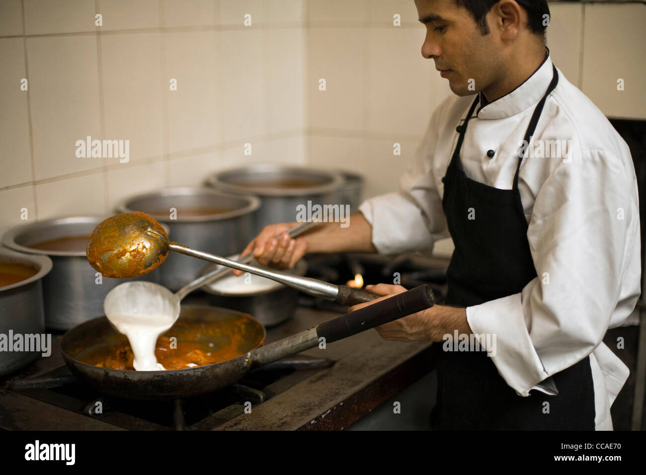 Ein Koch bereitet eine Schüssel mit Butter Huhn im Moti Mahal Restaurant in Alt-Delhi, Indien Stockfoto
