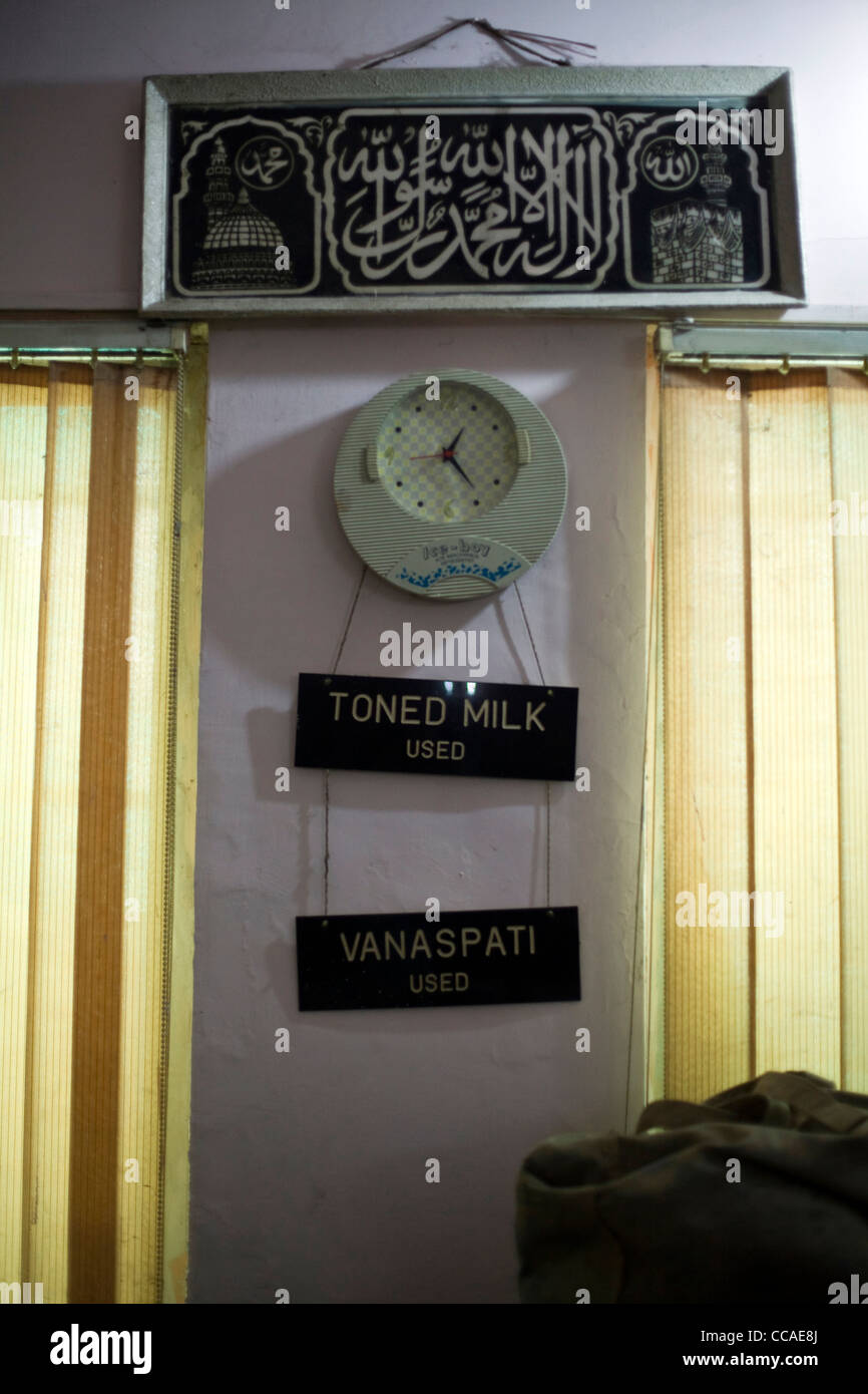 Eine Uhr und ein Zeichen von der Theke im Moti Mahal Restaurant in Alt-Delhi, Indien Stockfoto
