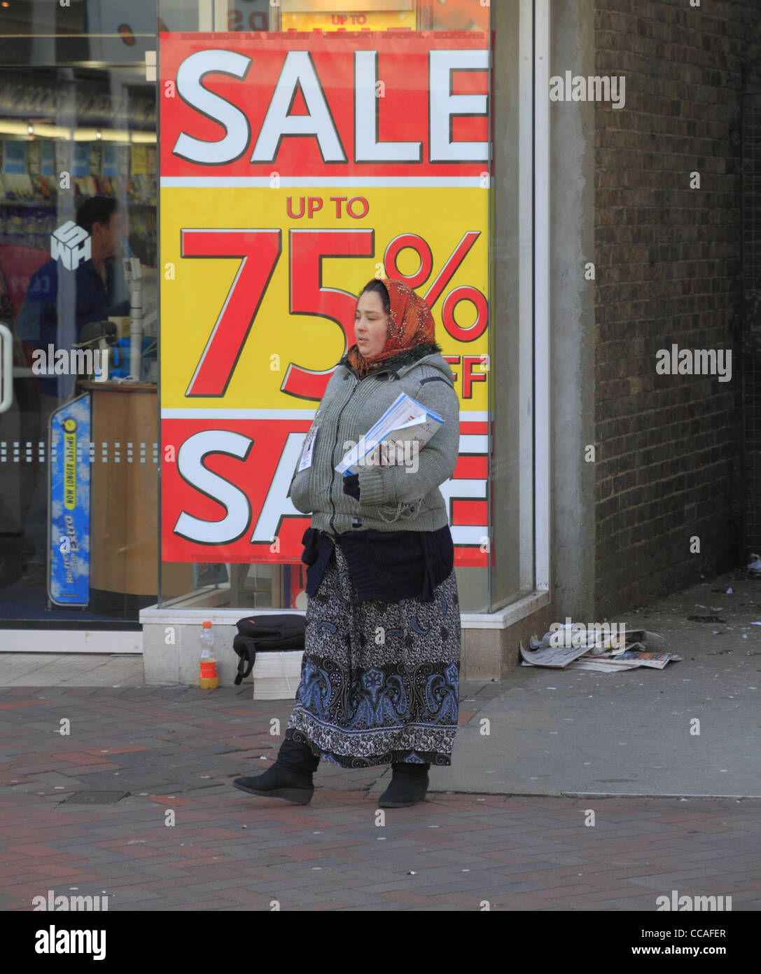 Eine östliche europäische Frau The Big Issue auf einer Straße in Eastbourne, East Sussex, England zu verkaufen. Stockfoto