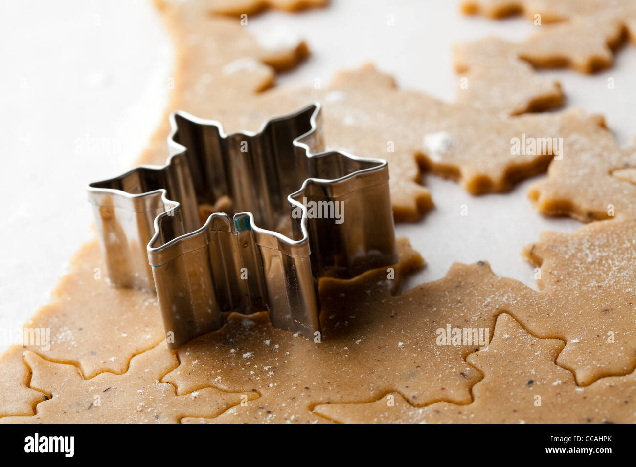 Lebkuchen zu Weihnachten zu machen. Lebkuchenteig mit Sternformen und einem Cutter. Stockfoto