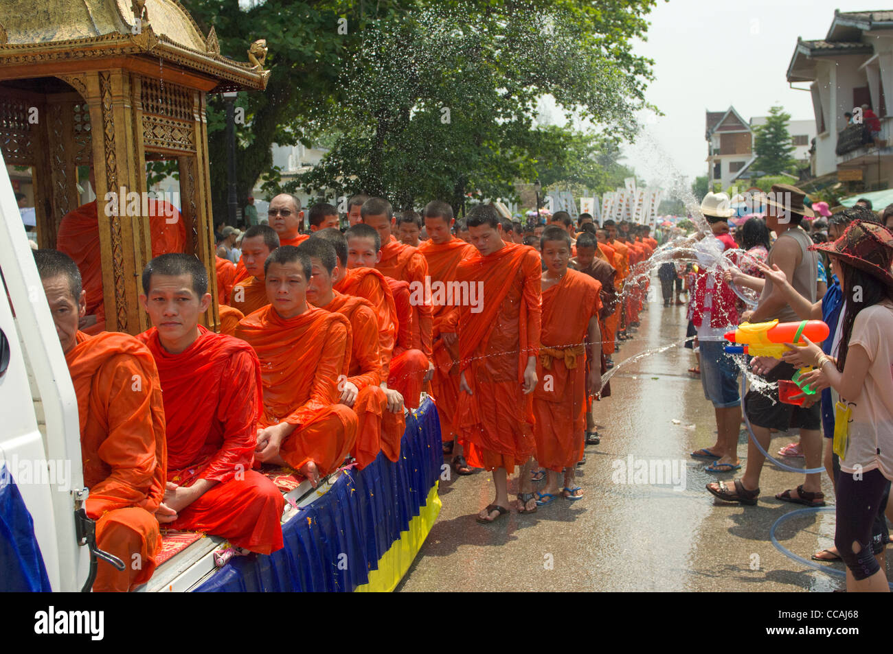 Buddhistische Mönche in einer Prozession mit Wasser geworfen über sie für Segen, Mue Nau, Lao Neujahr (Pi Mai Lao), Luang Prabang, Laos Stockfoto