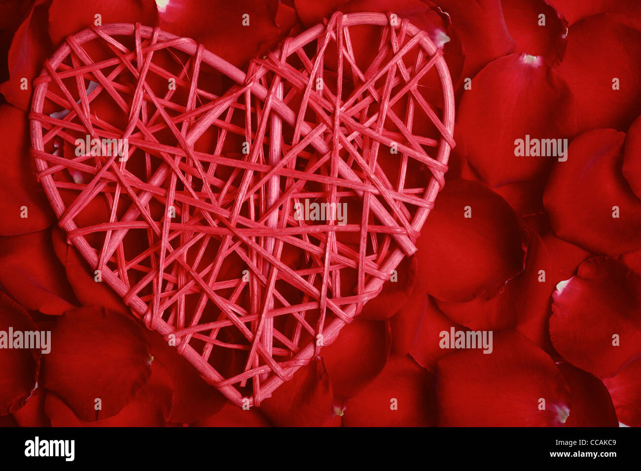 Handgemachte rotes Herz auf Rosenblättern Hintergrund Stockfoto