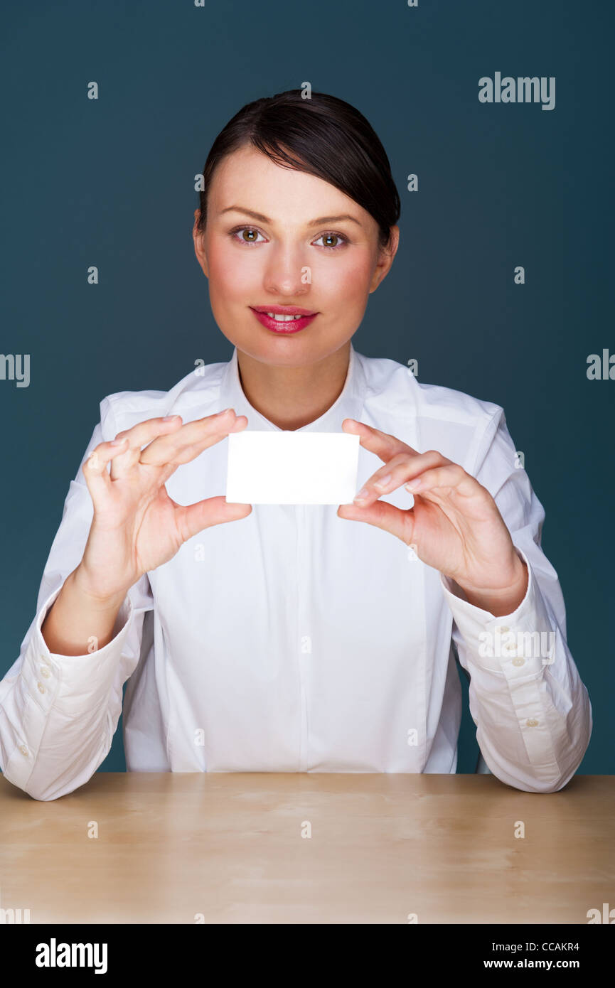 Junge Geschäftsfrau zeigt ihre Visitenkarte - sitzen in ihrem Büro Stockfoto