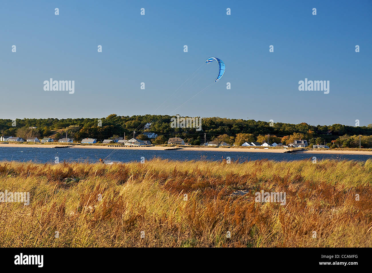 Eine herbstliche Aussicht auf Kitesurfer in der Ferne Vergangenheit Sumpf Gräser im Herbst Stockfoto