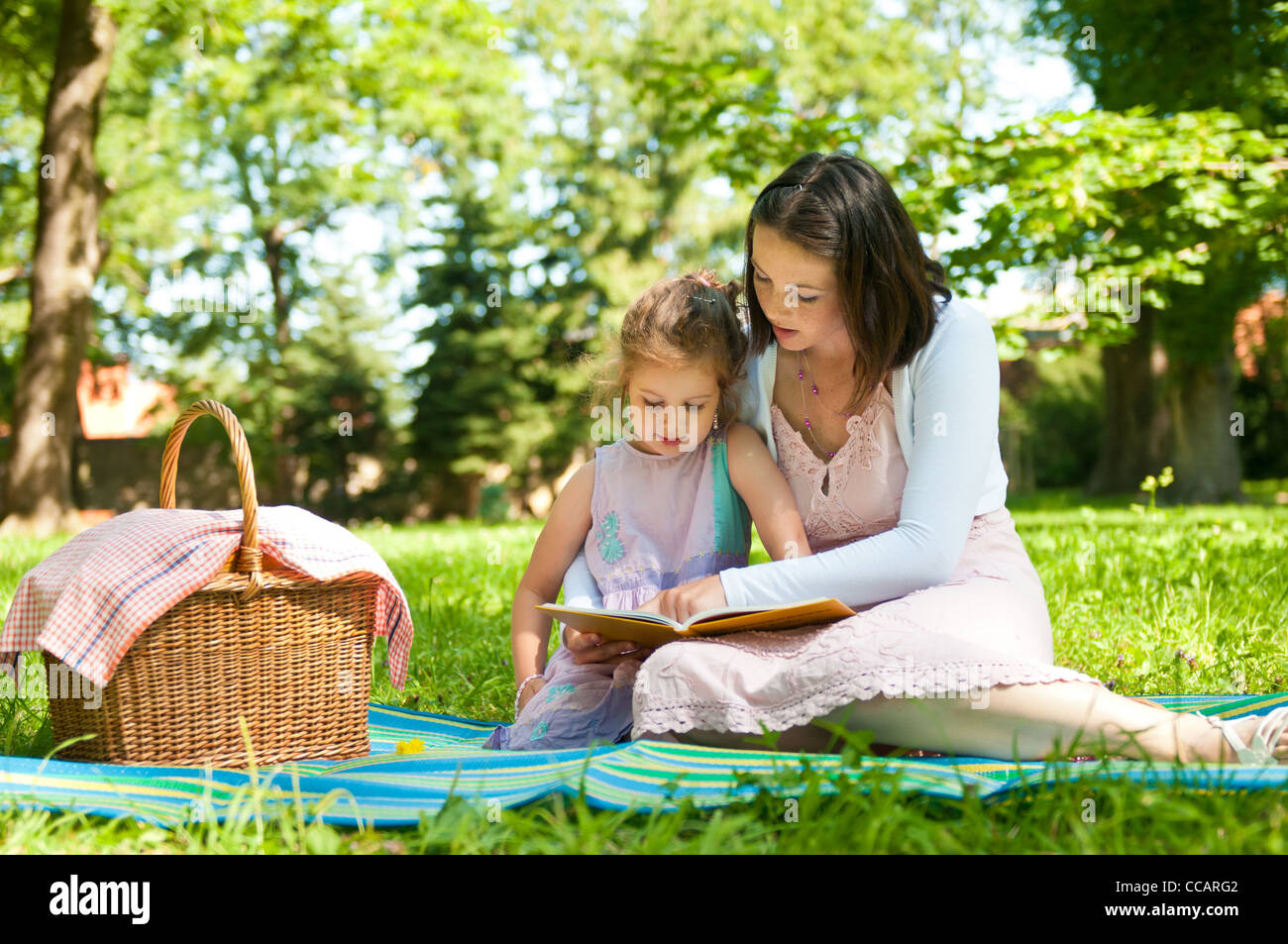 Mutter und Kind Lesebuch Picknick im park Stockfoto