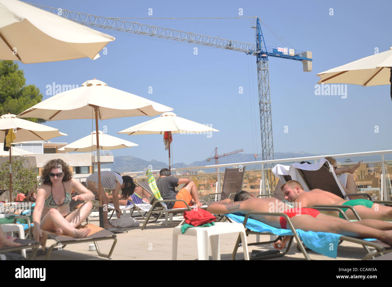 Urlauber auf Mallorca auf einer Hotelterrasse mit Hochbau im Hintergrund Stockfoto