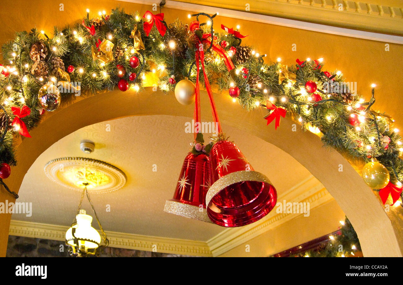 Glocken und Lichterketten als Bestandteil der Weihnachtsschmuck in einem irischen Pub. Stockfoto