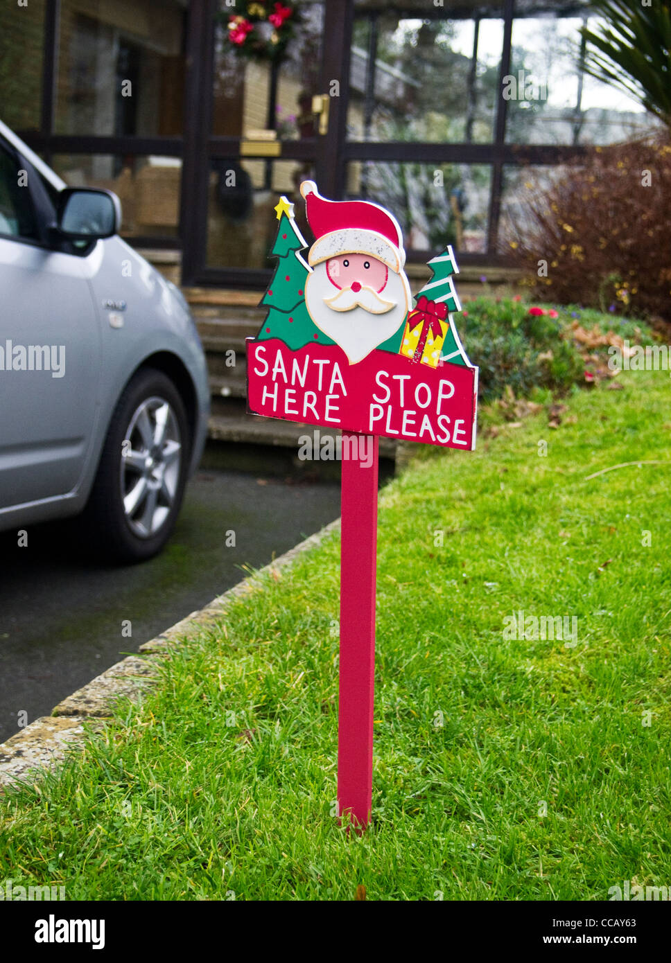 Santa Bitte aufhören hier - ein Zeichen in der Wiese im Garten eines Hauses, wo Kinder auf Heiligabend erwartet Geschenke warten Stockfoto