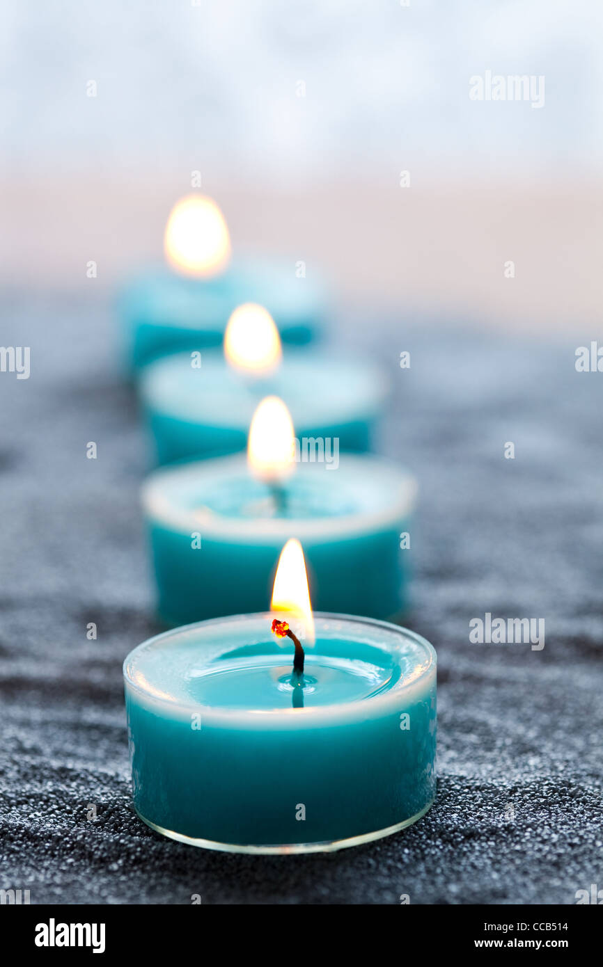 Nahaufnahme des blauen Kerzen auf silbernen sand Stockfoto