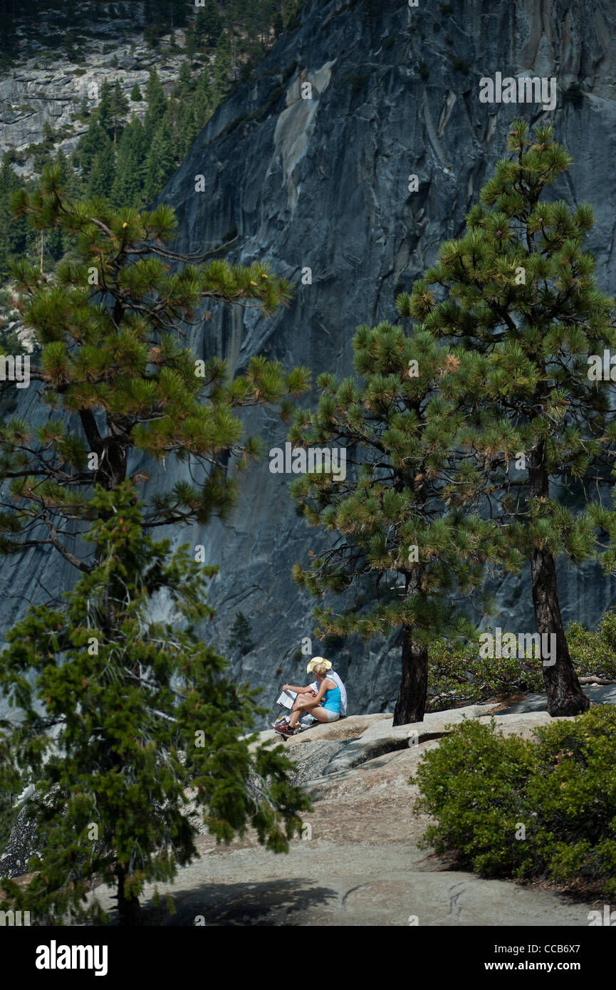 Ein junges Paar, sitzen und Ausruhen auf dem Granit an der Spitze der Nevada fällt. Yosemite-Nationalpark. Kalifornien. USA Stockfoto