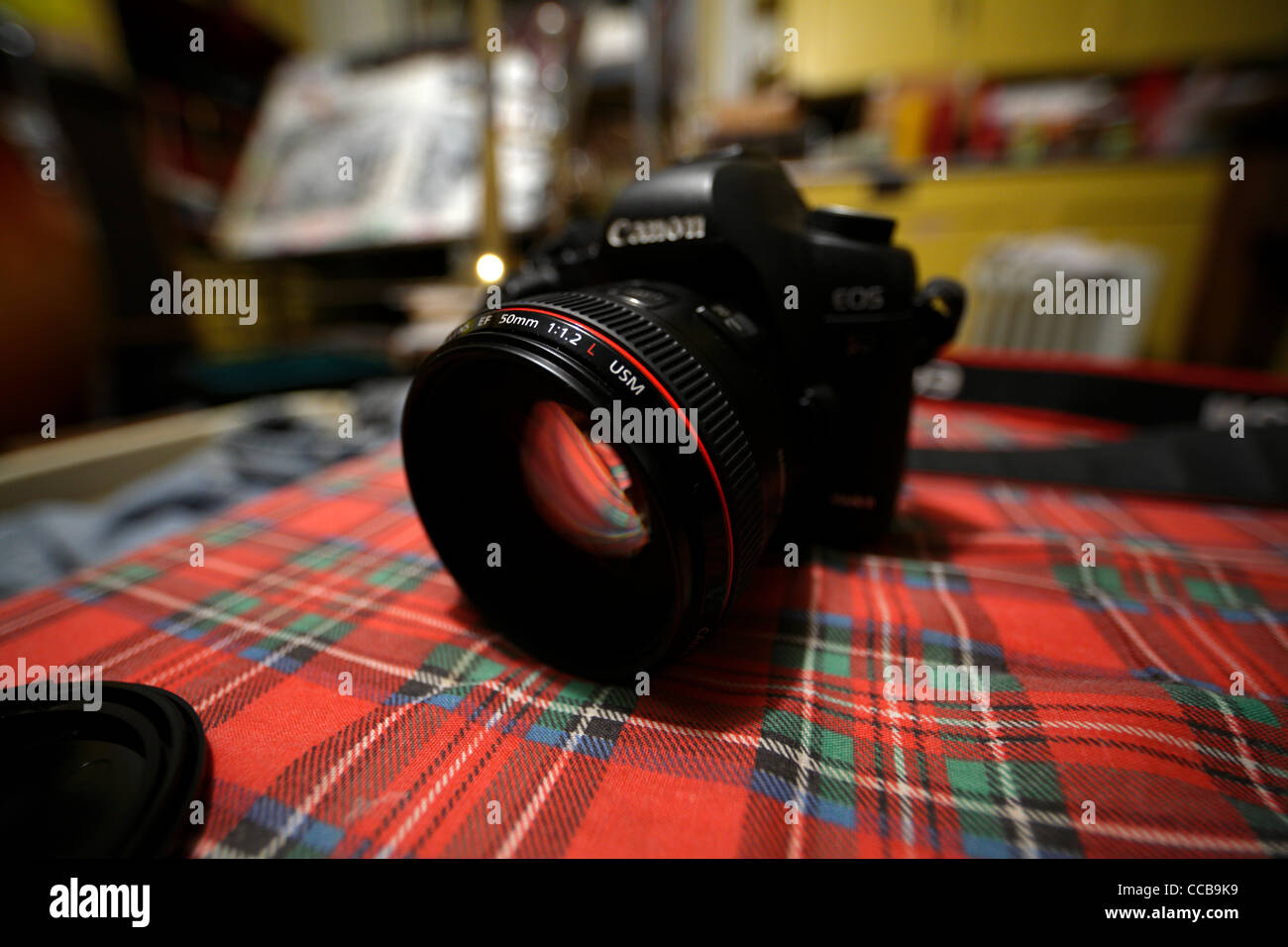 Canon 5D mark II mit EOS 50mm f/1.2 Objektiv auf rot karierten Oberfläche. Stockfoto
