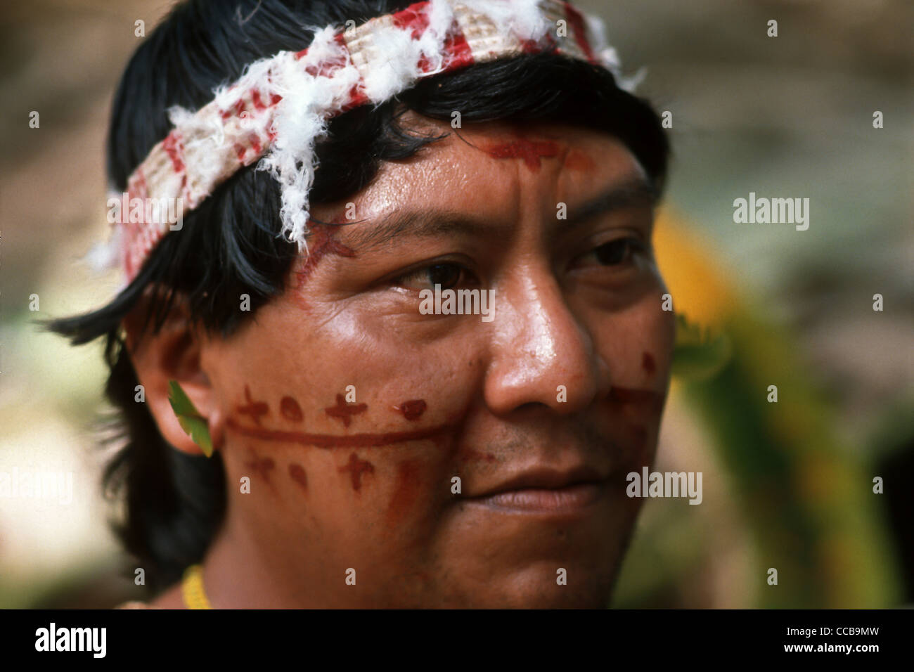 Roraima, Brasilien. Chief Davi Yanomami, Führer der Yanomami und ihre Sprecher, Baumwolle und Feder Kopfschmuck tragen und mit rotem Gesicht malen Design. Stockfoto