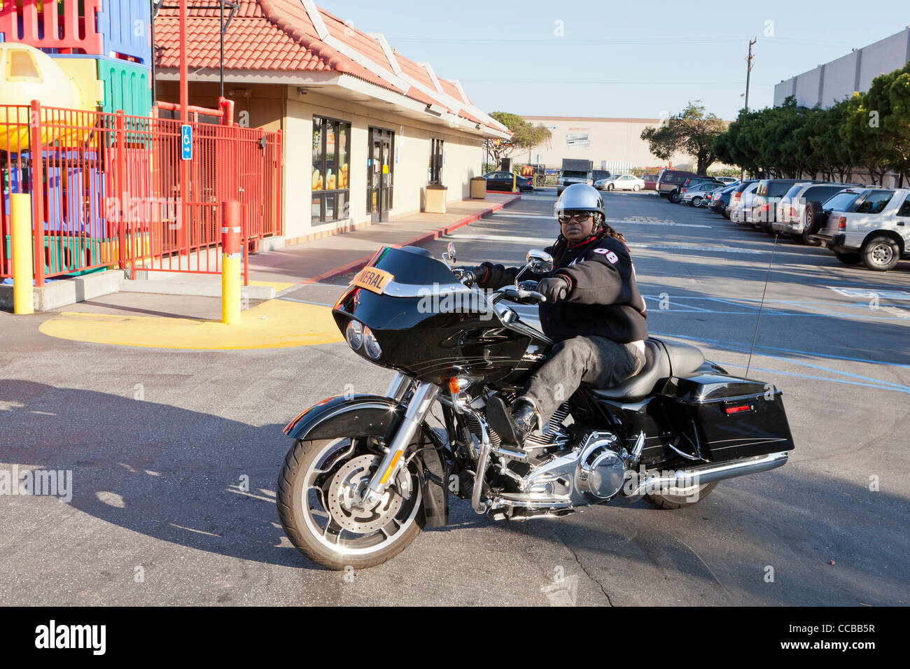 Eine Afroamerikanerin sitzt auf einem Harley Davidson Motorrad Stockfoto