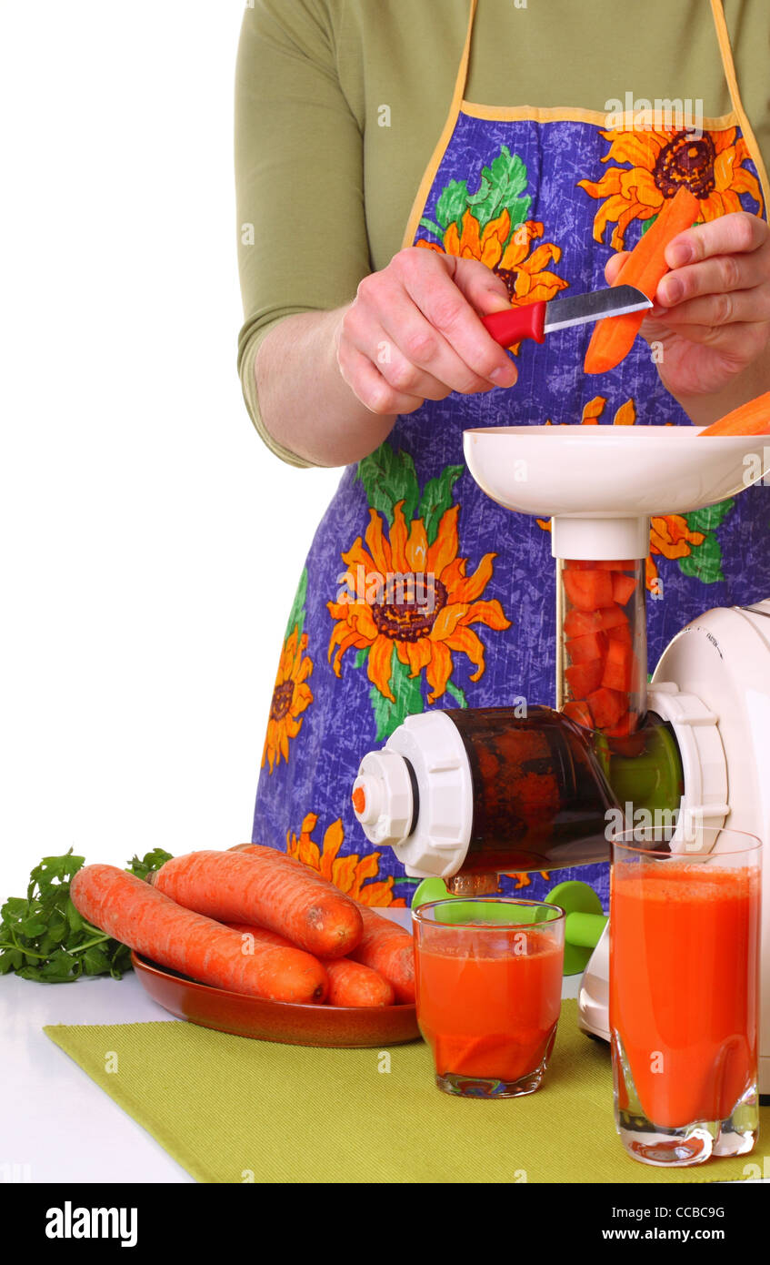 Frau Entsafter und Karotte isolierten weißen Küche vorbereiten Stockfoto