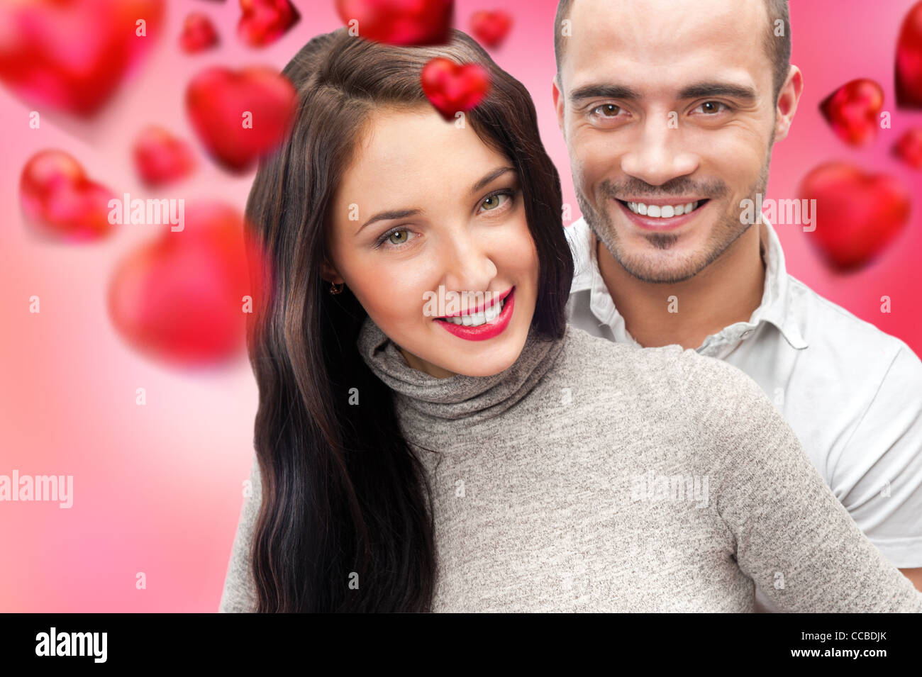 Schöne junge Paar umarmt und Blick in die Kamera. Am romantischen Hintergrund, gestaltet im Stil von Valentine und bereit stehen Stockfoto