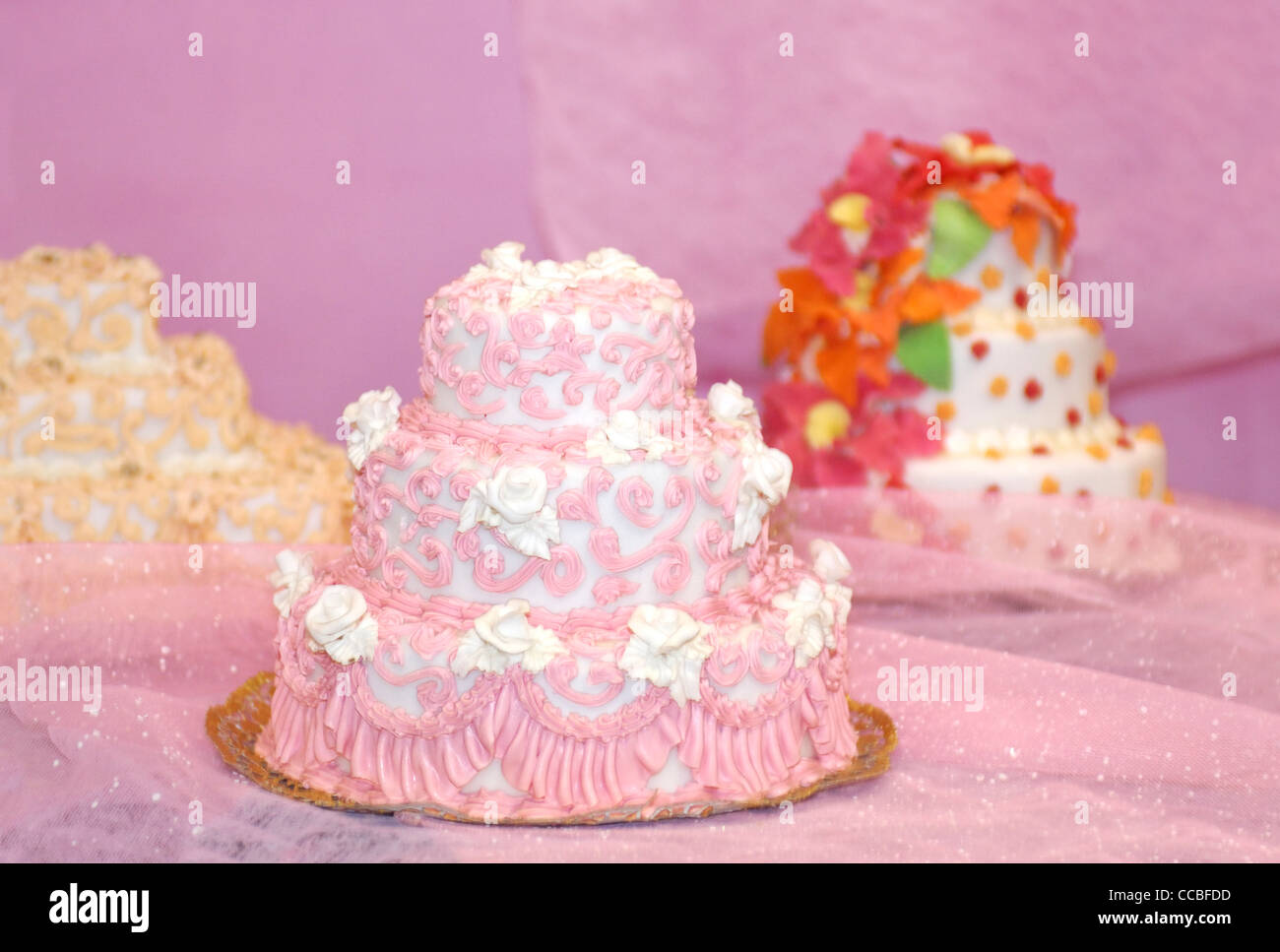 Bunte ausgefallene vielschichtige Hochzeitstorten auf rosa Hintergrund Stockfoto