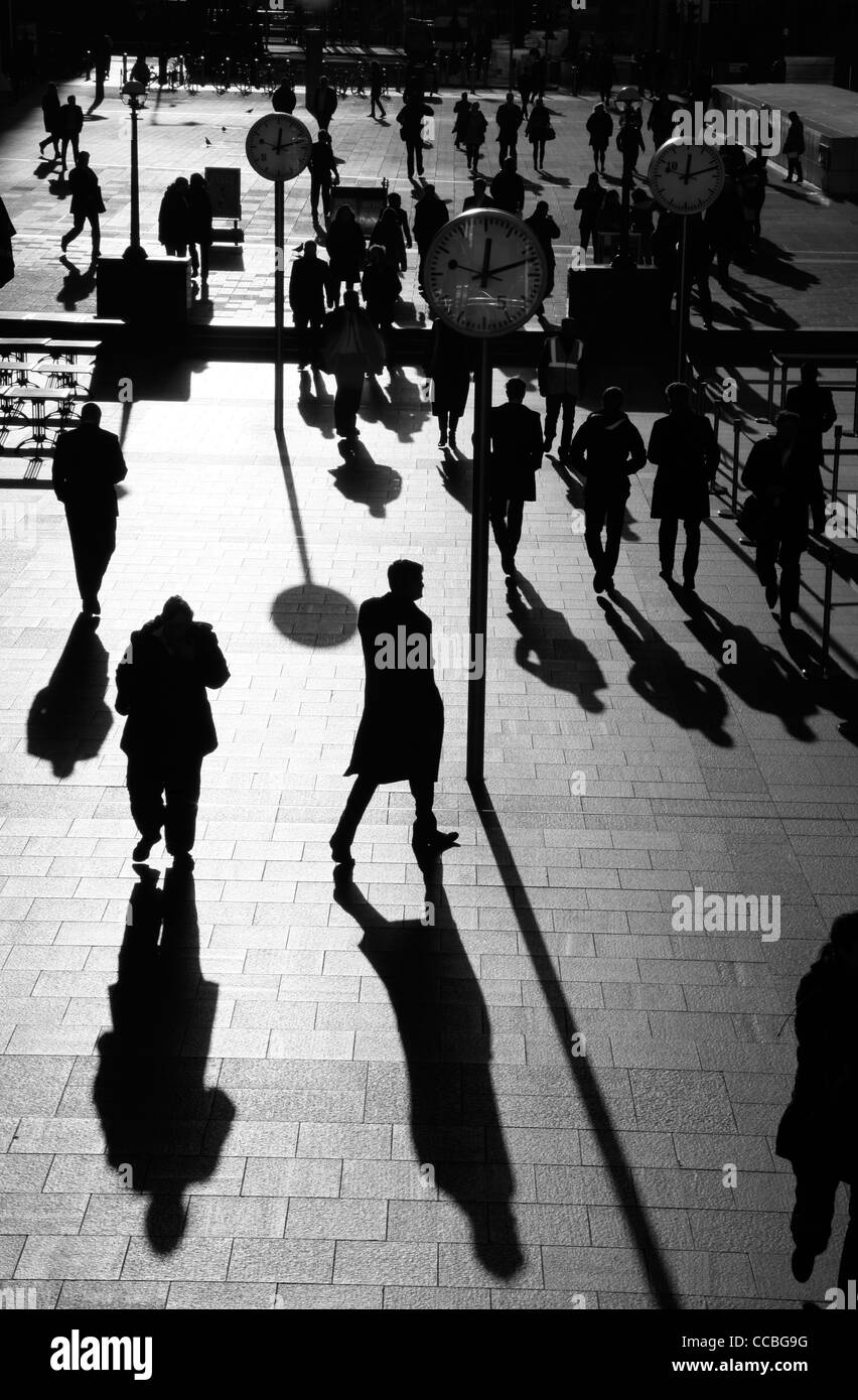 Schatten und Silhouetten der Fußgänger zu Fuß durch Reuters Plaza, Canary Wharf, London, UK Stockfoto