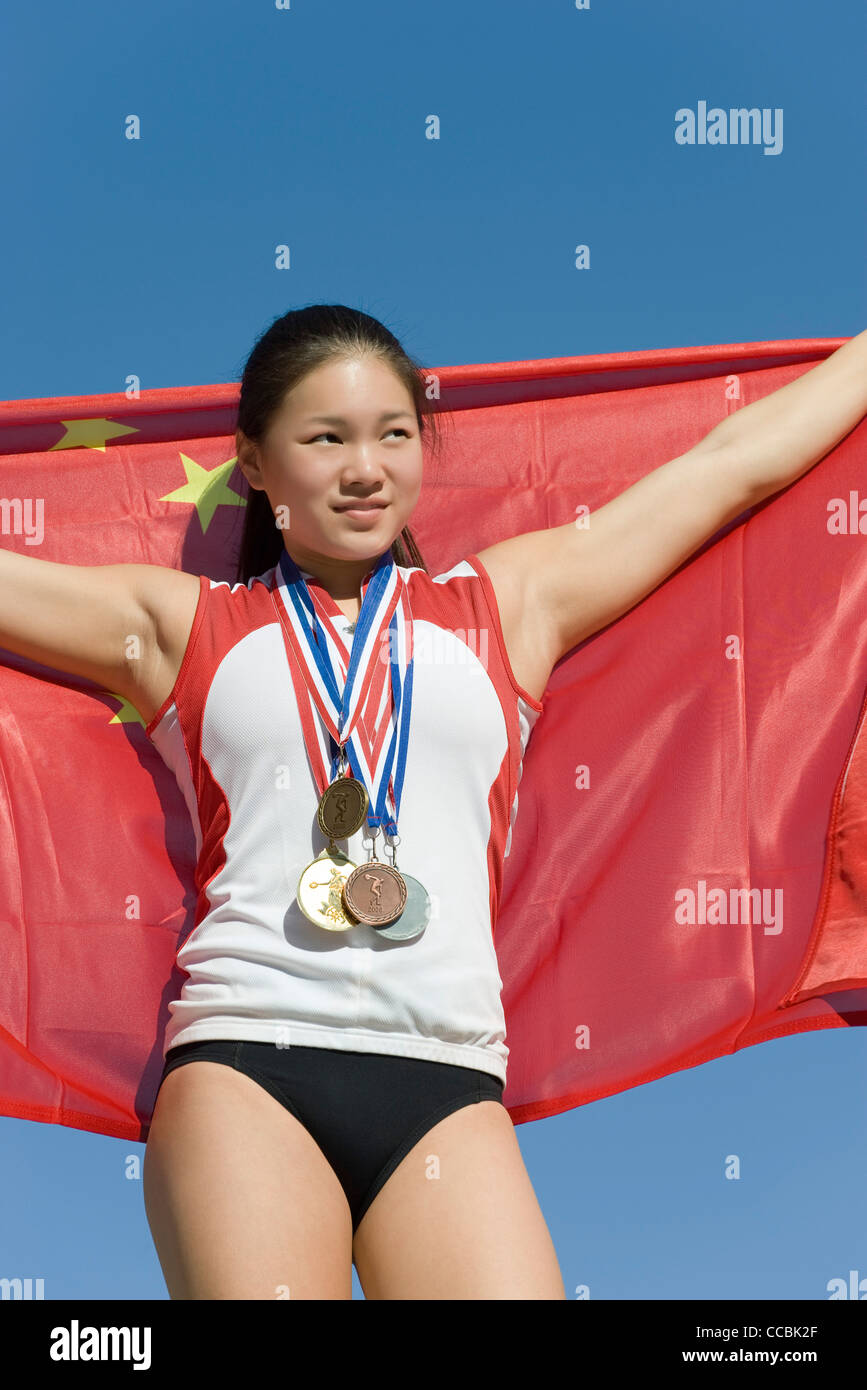 Sportlerin auf Siegertreppchen, chinesische Flagge Stockfoto
