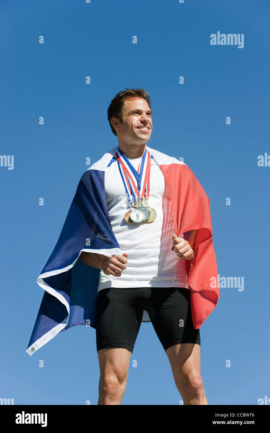 Männliche Sportler geehrt auf Podest, eingehüllt in französische Flagge Stockfoto