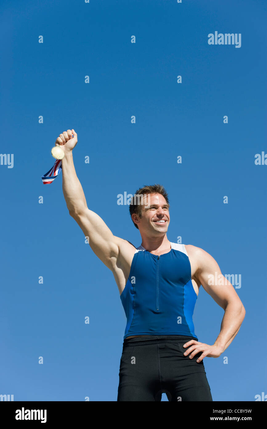 Männlicher Athlet hält Goldmedaille Stockfoto
