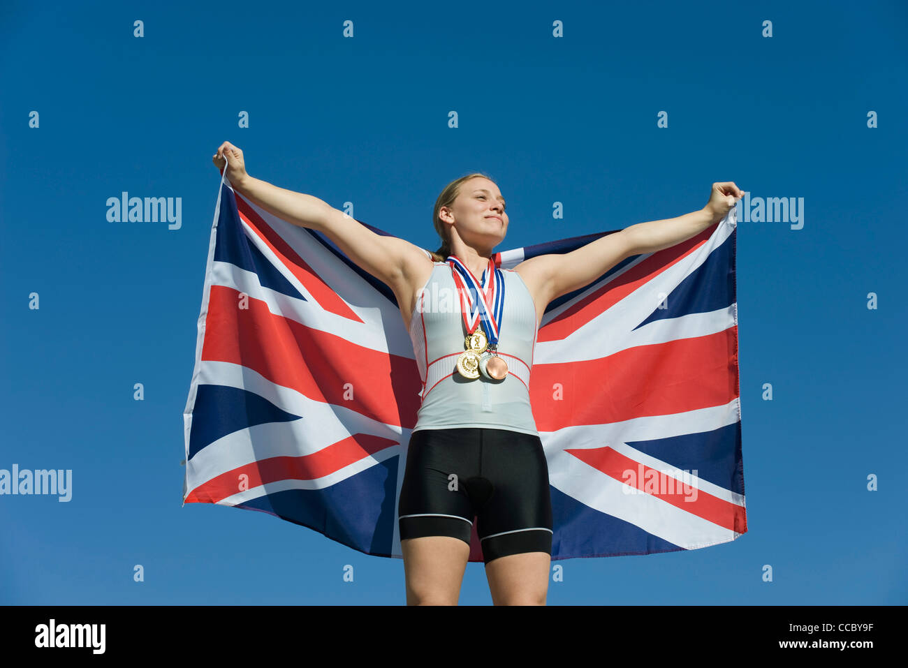 Weiblichen Athleten geehrt auf Podest, britische Fahne hochhalten Stockfoto
