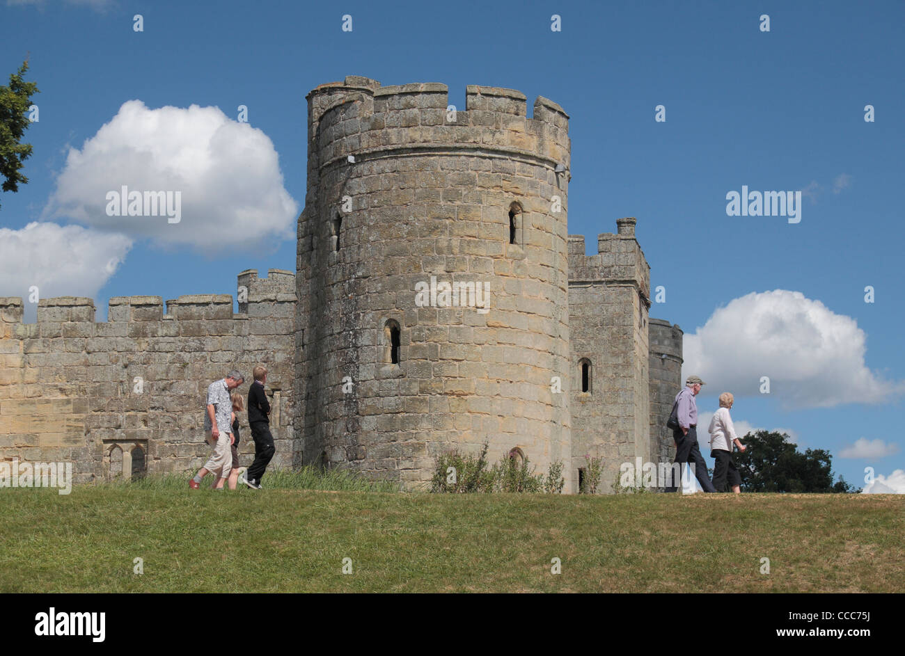 Besucher, die an der Wand der Graben vor dem Süd-Ost-Turm des 14. Jahrhunderts Bodiam Castle, East Sussex, England UK. Stockfoto