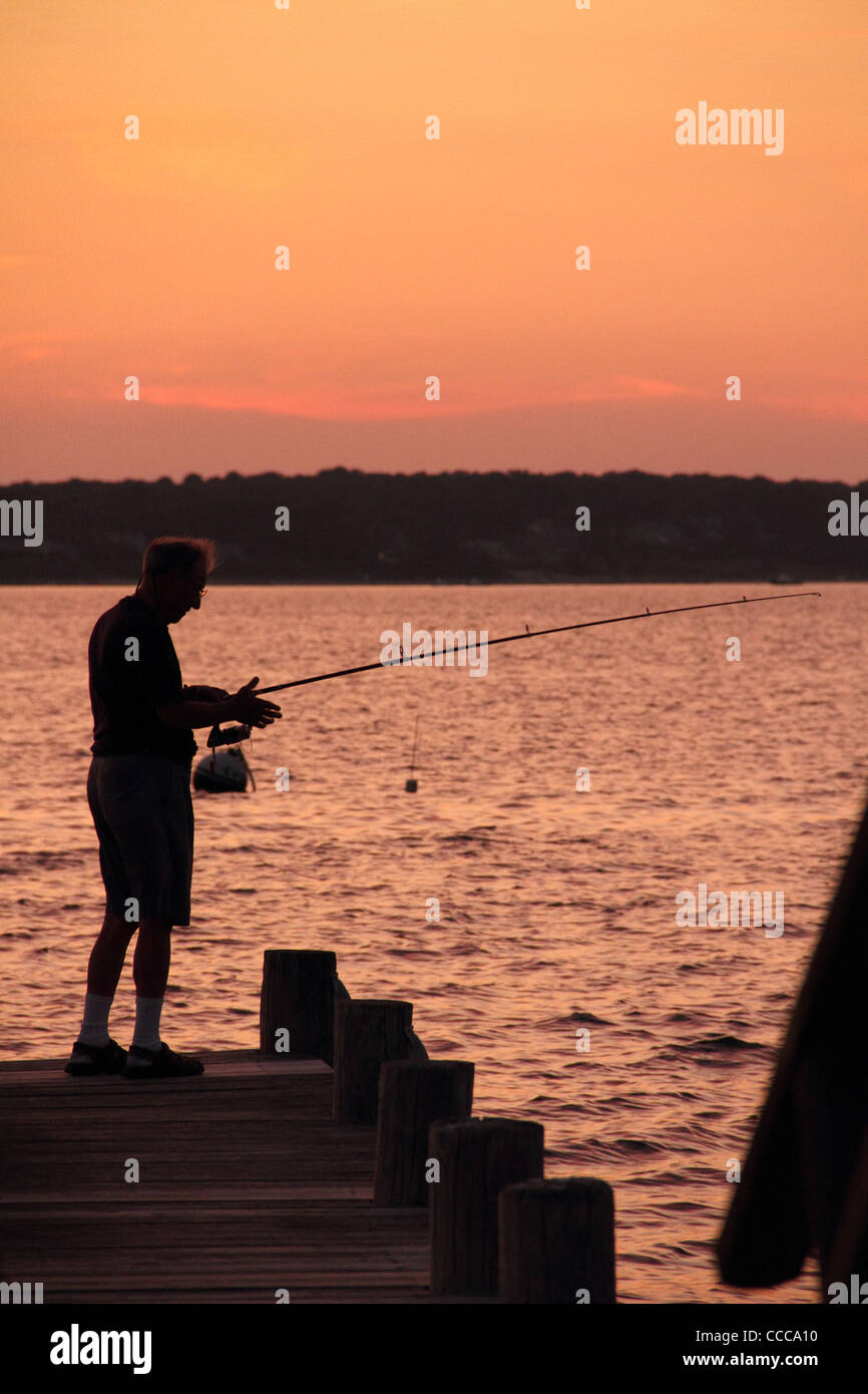 ältere männliche Angeln bei Sonnenuntergang vom pier Stockfoto