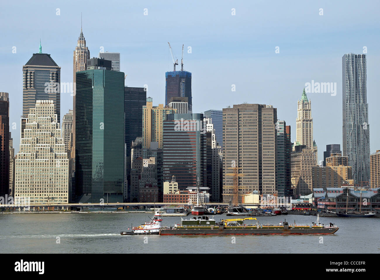 Ein Blick auf Lower Manhattan und ein Lastkahn im East River. New York City, New York, Vereinigte Staaten von Amerika Stockfoto