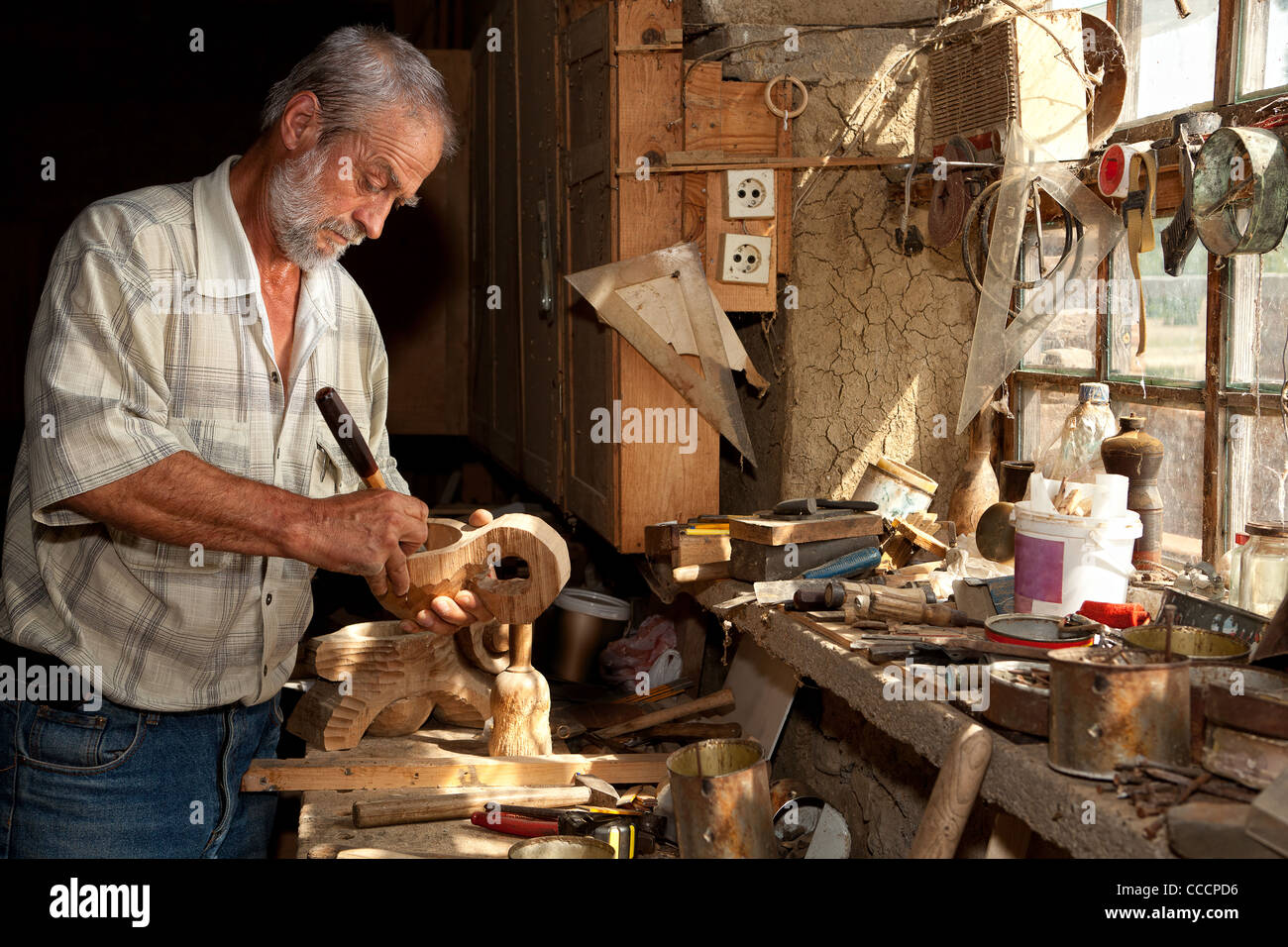 Hölzerne Arbeitskraft Schnitzen von Holz in einem verlassenen Schuppen Stockfoto