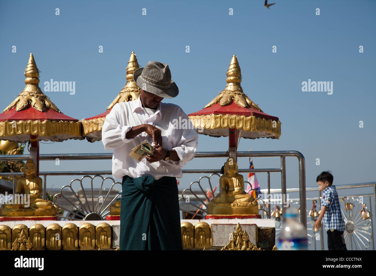 Golden Rock mit einem Umsatz Mann Geld sammeln für Opfer - eines der meisten buddhistischen Kultstätte in Birma. Stockfoto