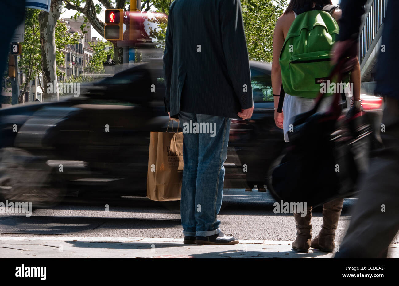 Menschen warten, um an einer Straßenkreuzung in Barcelona, Spanien zu überqueren. Mit einem roten Mann-Stop-Schild darauf hinweist nicht kreuzen. Stockfoto