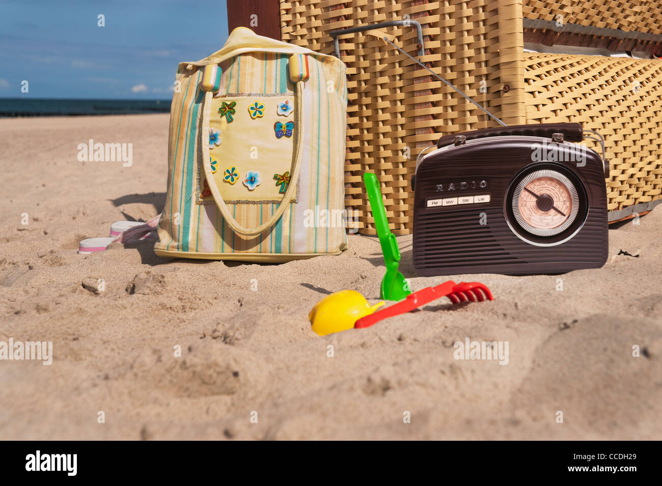 Strand Stuhl, daneben sind ein Radio, eine Strandtasche und Spielzeug für den Strand Stockfoto