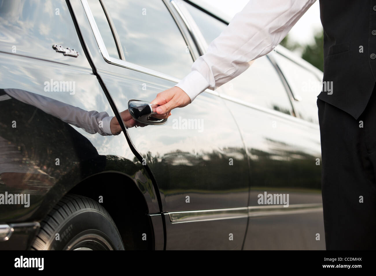 Ein Chauffeur öffnet die Tür einer Limousine Stockfoto