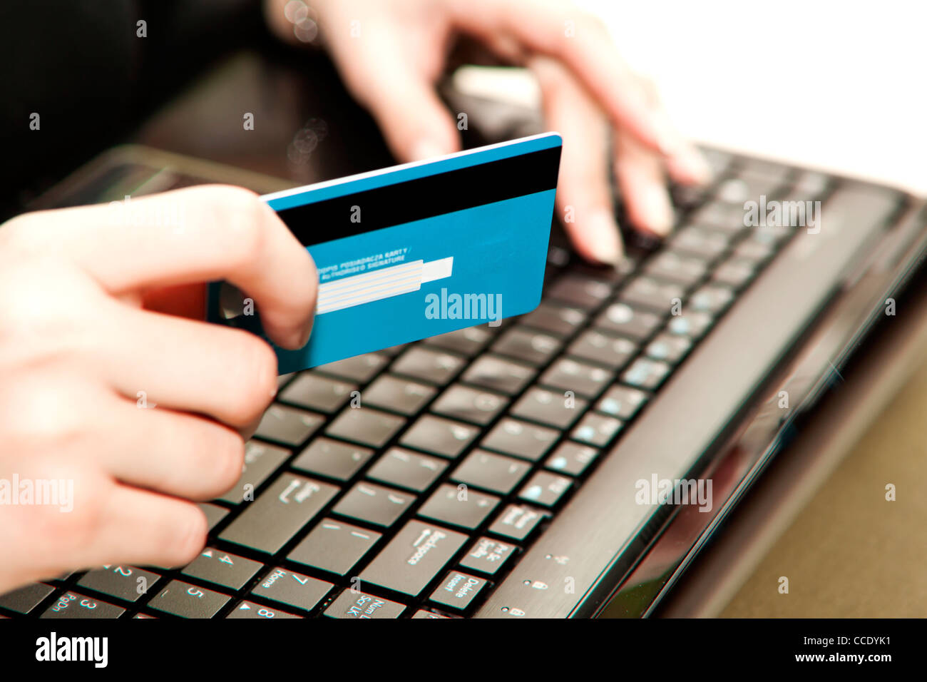 Hände, die Eingabe von Kreditkarteninformationen in einen laptop Stockfoto