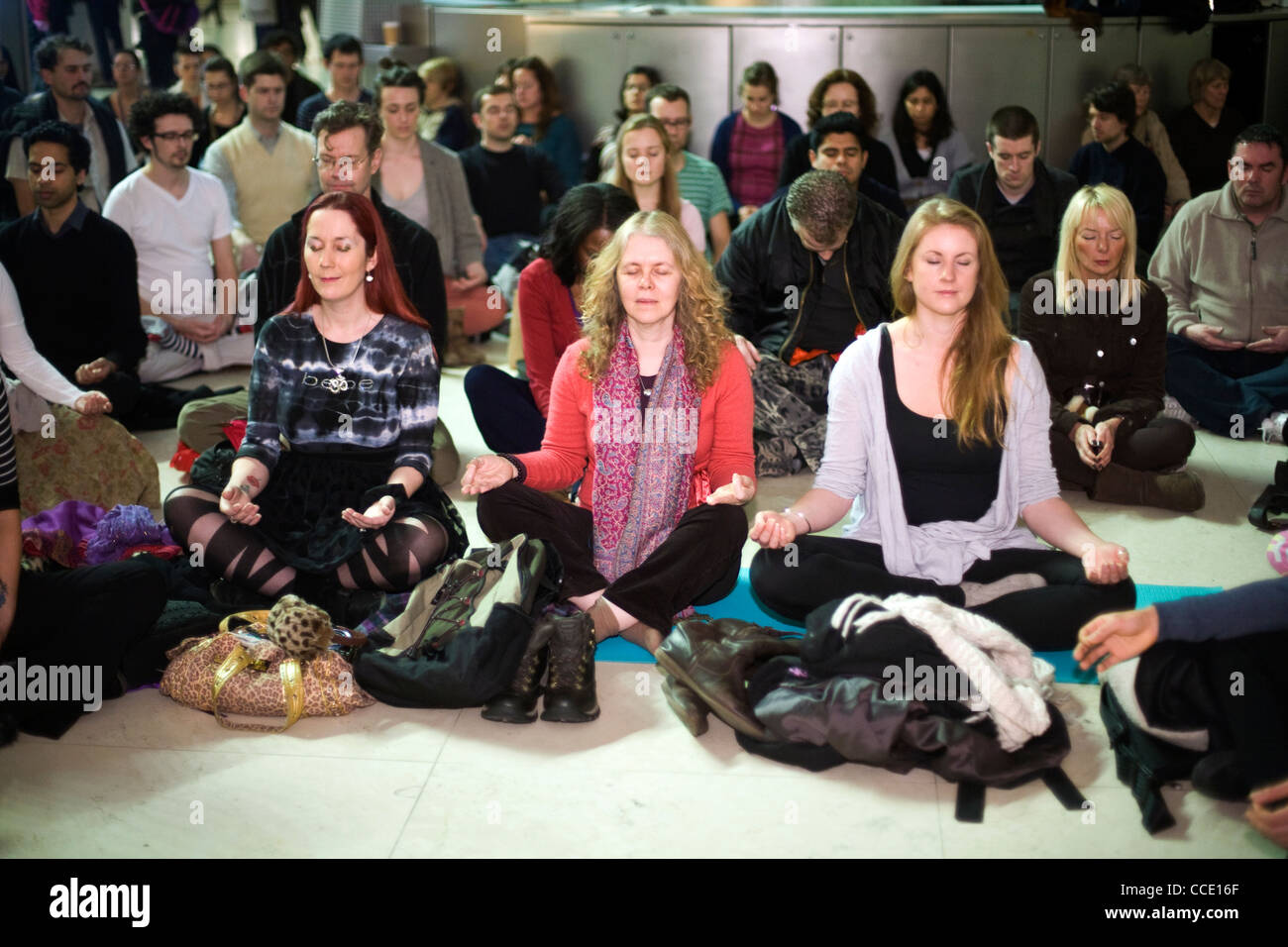 Menschen meditieren als Bestandteil einer Meditation-Flashmob in der Great Court des British Museum Stockfoto