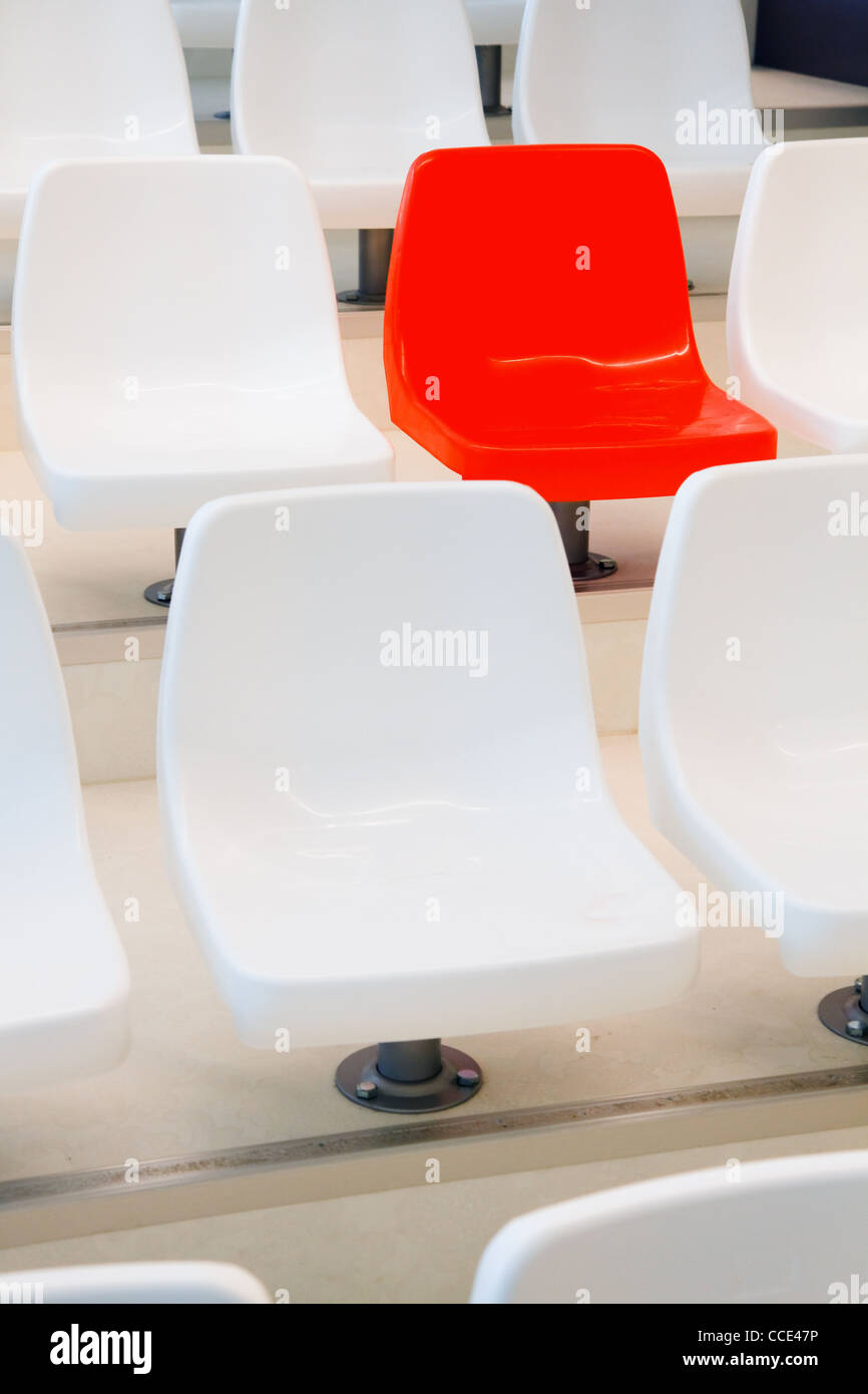 Alle Stühle sind weiß, rot - konzeptionelle - vertikales Bild ist Stockfoto