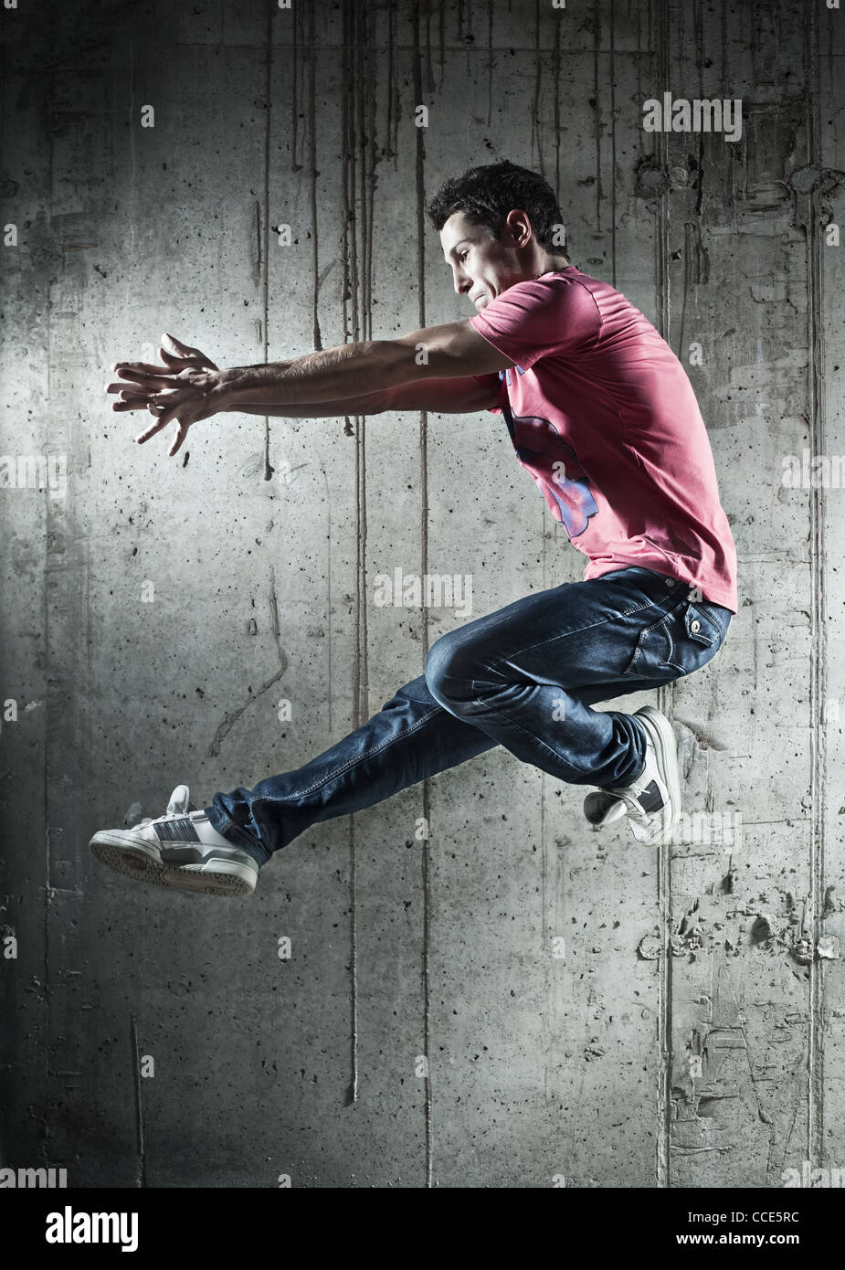 Junger Mann Tänzer springen. Auf Wand Hintergrund. Stockfoto