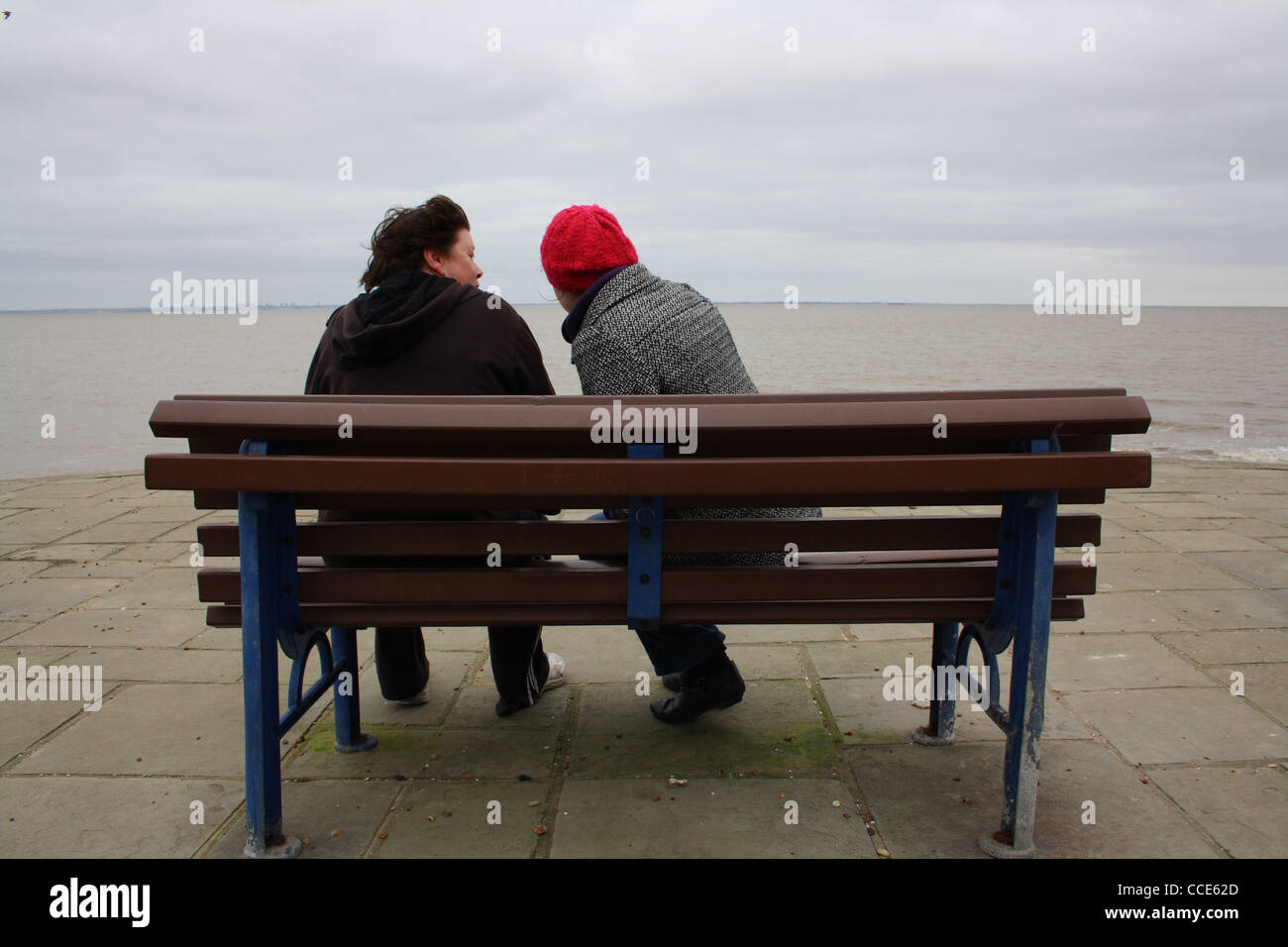 Zwei Frauen sitzen auf einer Bank am Meer. Stockfoto