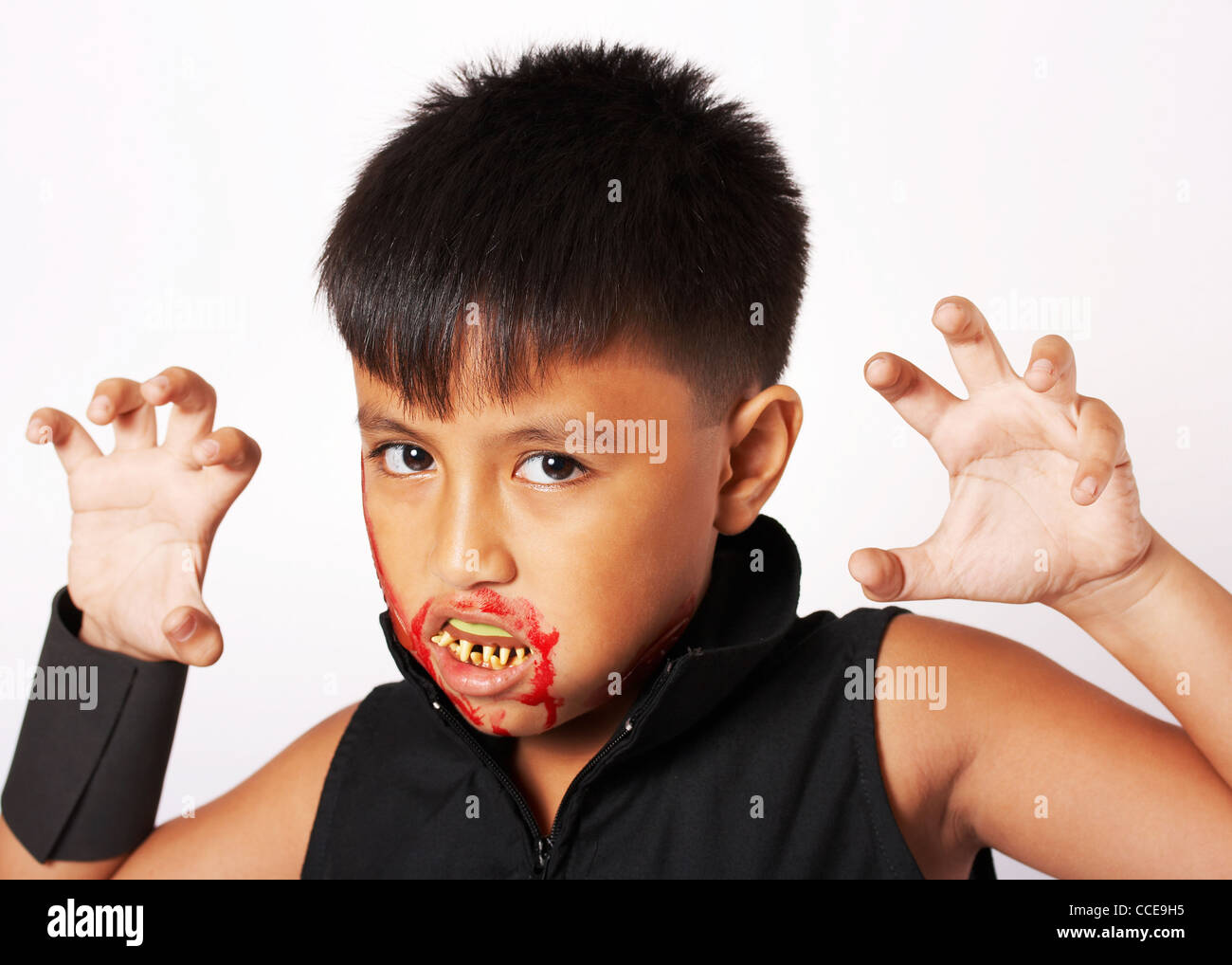 Junge mit Blut um den Mund für Halloween verkleidet und falsche Zähne Stockfoto