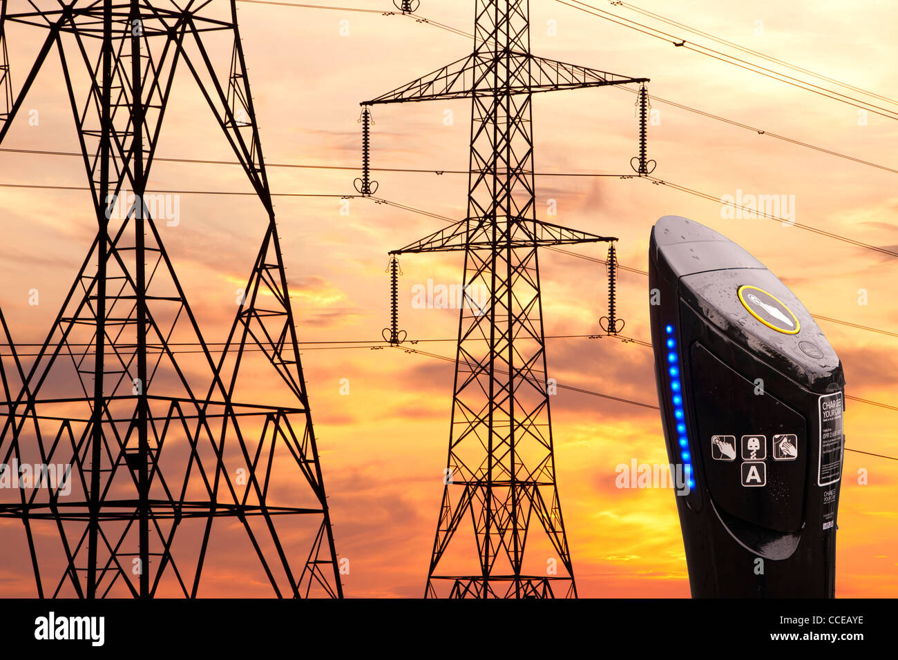 Stromleitungen und Masten bei Sonnenuntergang in Billingham, Teeside, UK und eine Ladestation Elektroauto. Stockfoto