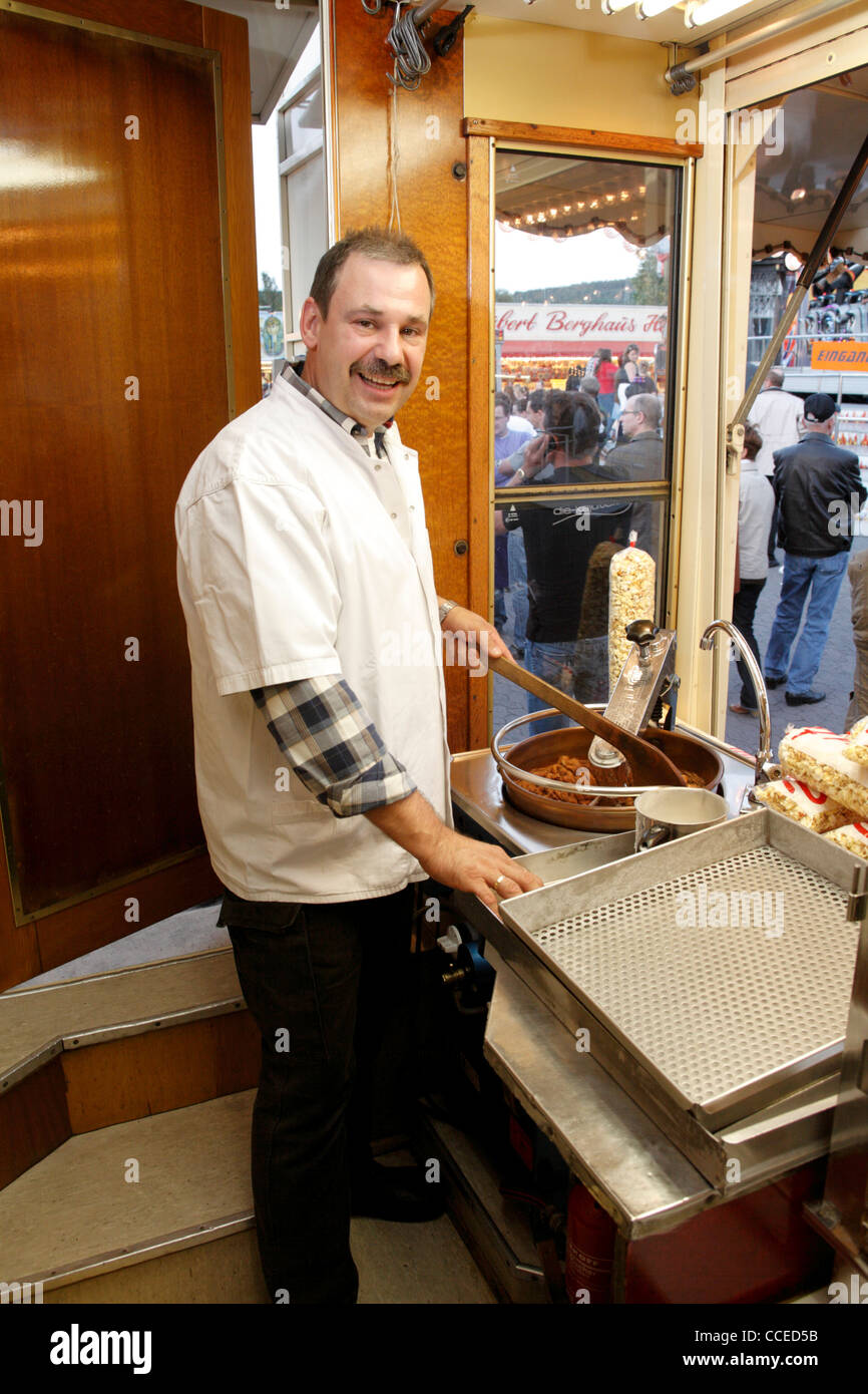 Verkäufer arbeiten bei Braten mit Mandeln an deutschen mobilen Verkaufsstand am Messe, Deutschland, Europa Stockfoto