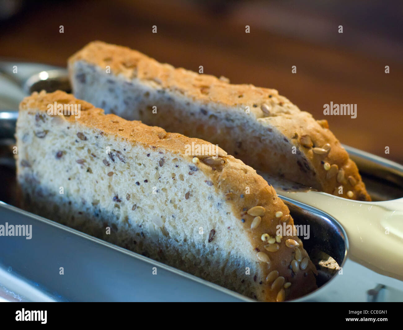 Zwei Scheiben Vollkornbrot braun ausgesät Brot stossen oben aus einem Chrom-Toaster. Stockfoto