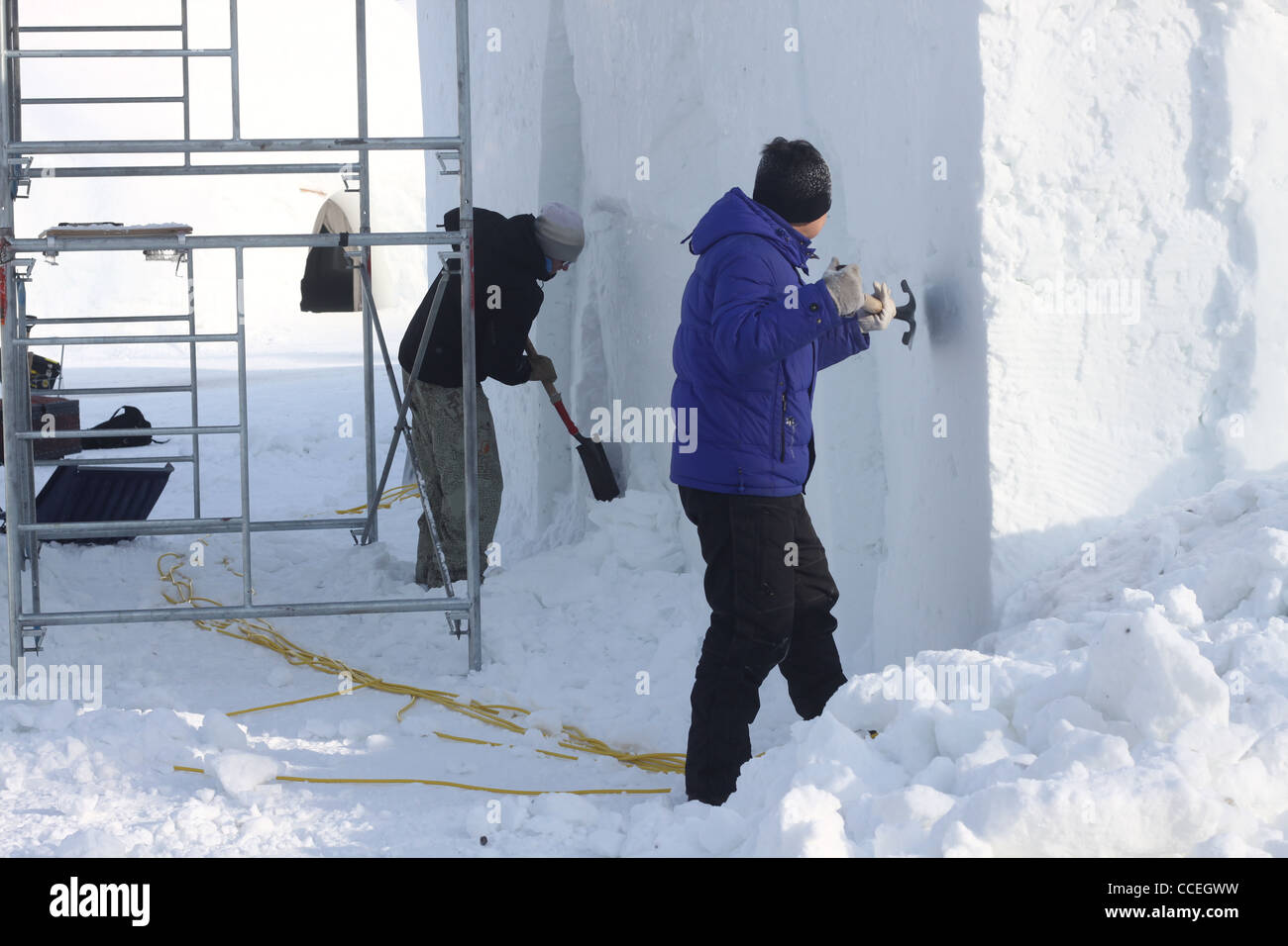 Zwei Schnee Bildhauer Meißeln Außenwände von Ice Hotel in Kanada Stockfoto