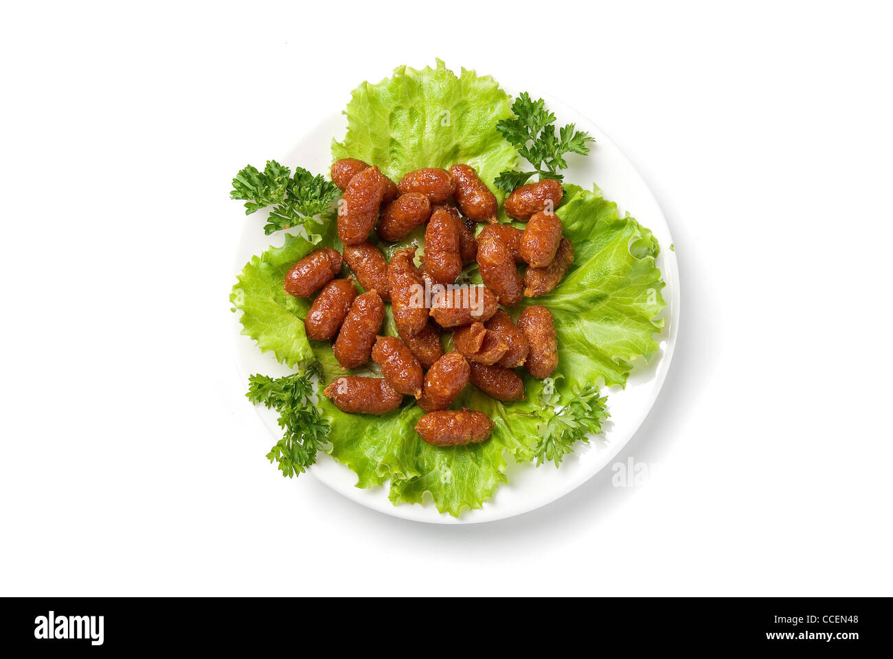 gegrillte Würstchen auf grünem Salat mit isoliert auf weiss Stockfoto