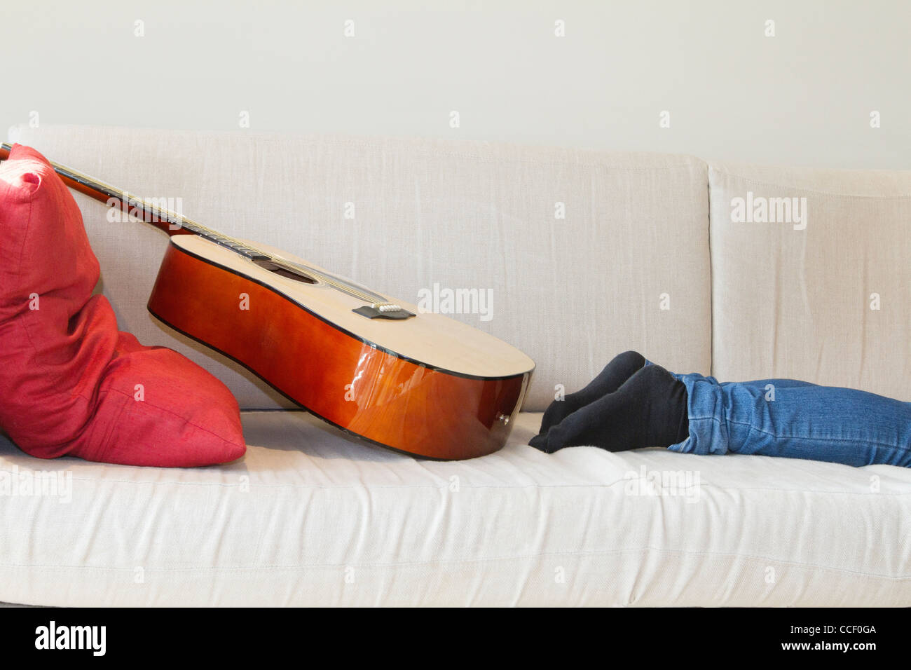 Geringen Teil des Mannes Bein mit Gitarre gehalten auf sofa Stockfoto