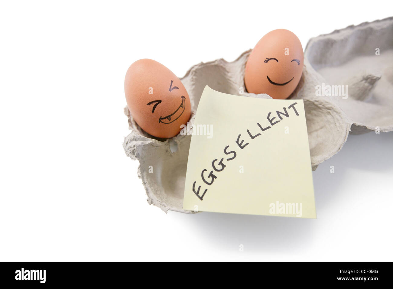 Smiley-Gesichter auf den Eiern mit "Eggsellent" geschrieben auf Briefpapier Stockfoto