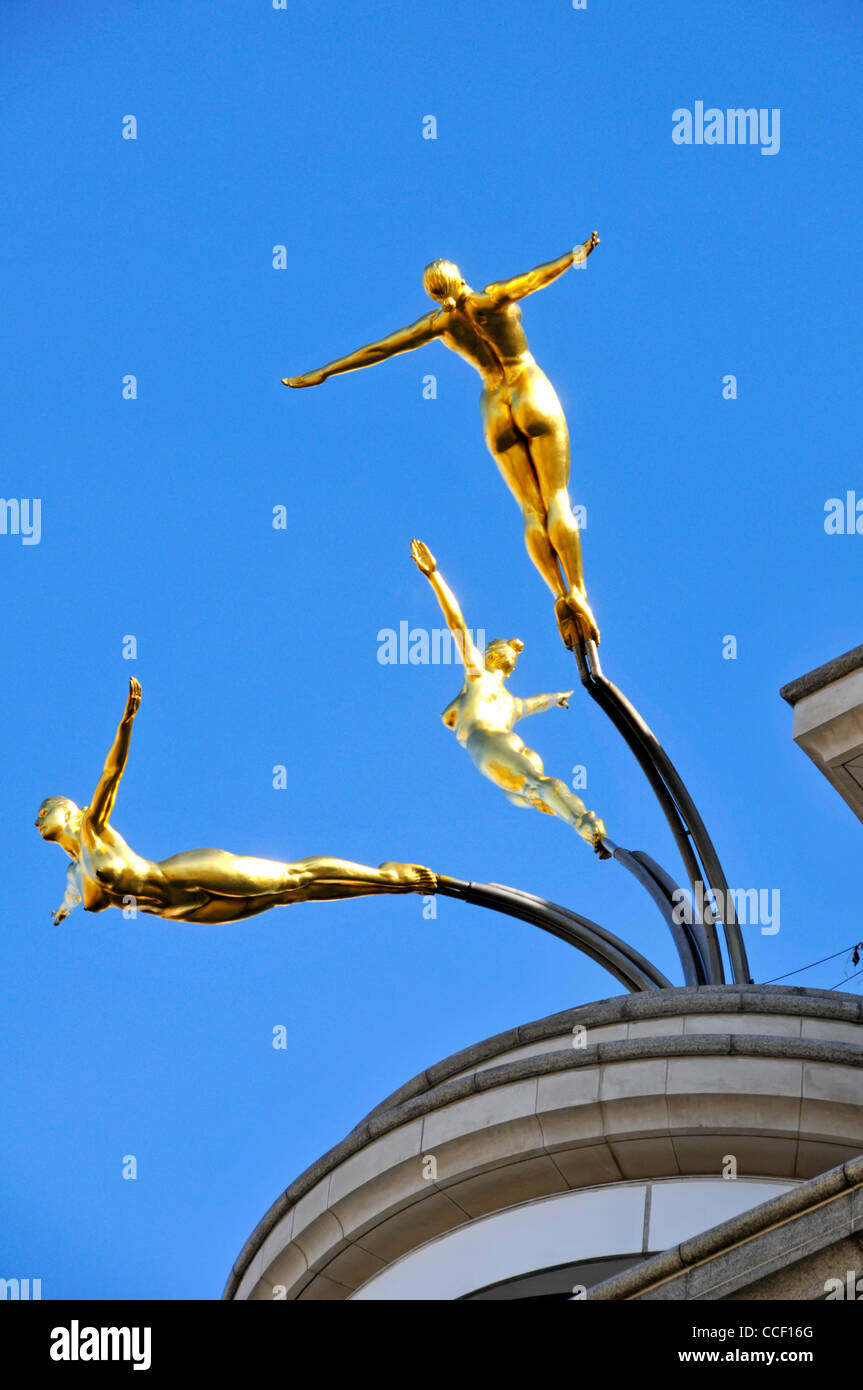 Skulptur auf dem Dach von Rudy Weller drei Gold nackte Frau tauchen aus Dach von Kriterium Gebäude in Coventry Street & Haymarket London England Großbritannien Stockfoto