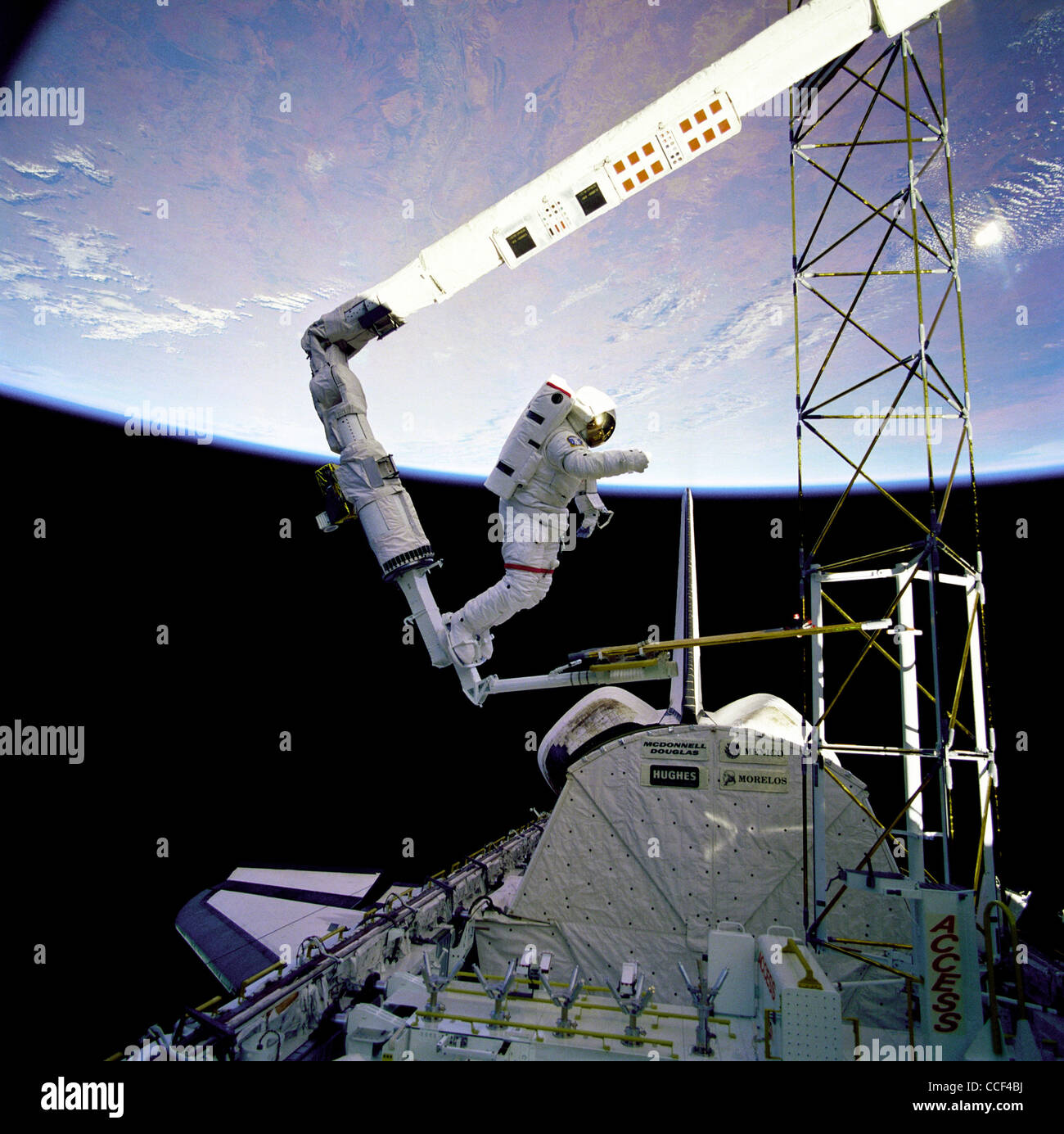 Astronaut Jerry L. Ross verankert an der Fuß-Fessel auf Remote Manipulator System (RMS) auf Space Shuttle Atlantis Stockfoto